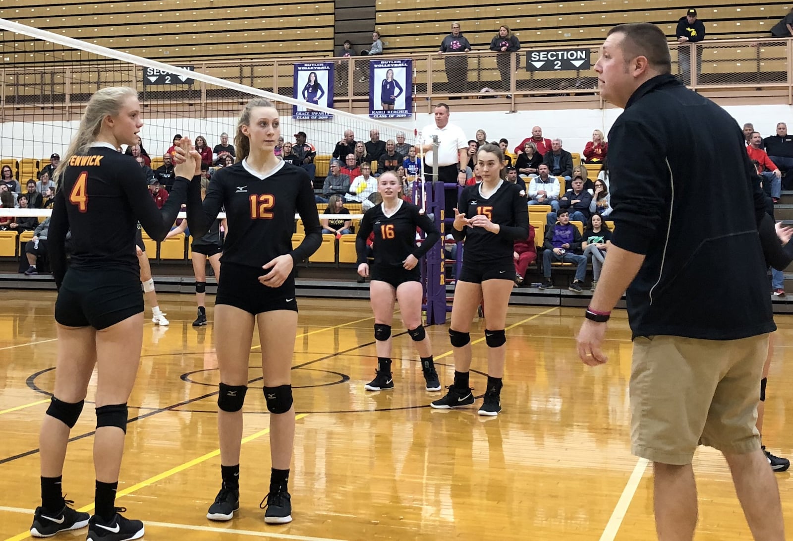 Fenwick’s Payton Deidesheimer (4) and Kate Hafer (12) look at Falcons coach Tyler Conley during a rotation in Saturday afternoon’s 3-2 victory over Roger Bacon in a Division II regional volleyball championship match at Vandalia Butler’s Student Activity Center. RICK CASSANO/STAFF