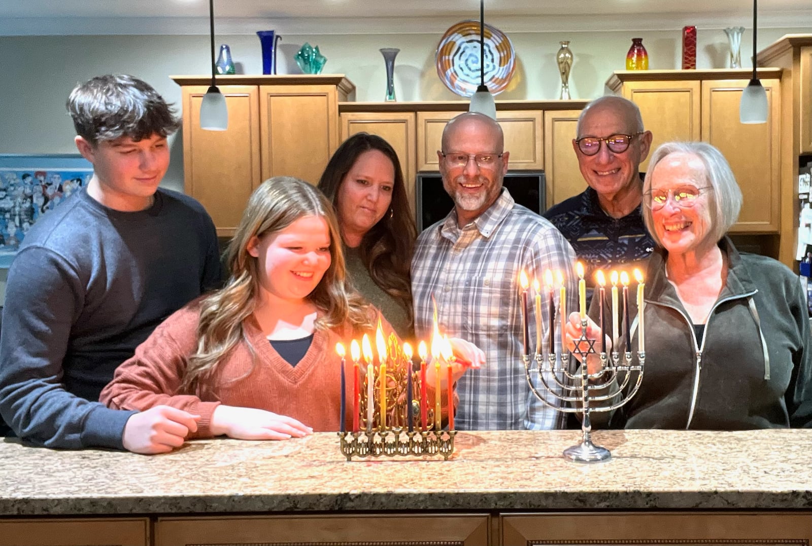 The Hochstein family lights the menorah. Pictured left to right are Cooper and Aubrey , Laura and Scott and grandparents Gary and Jane.