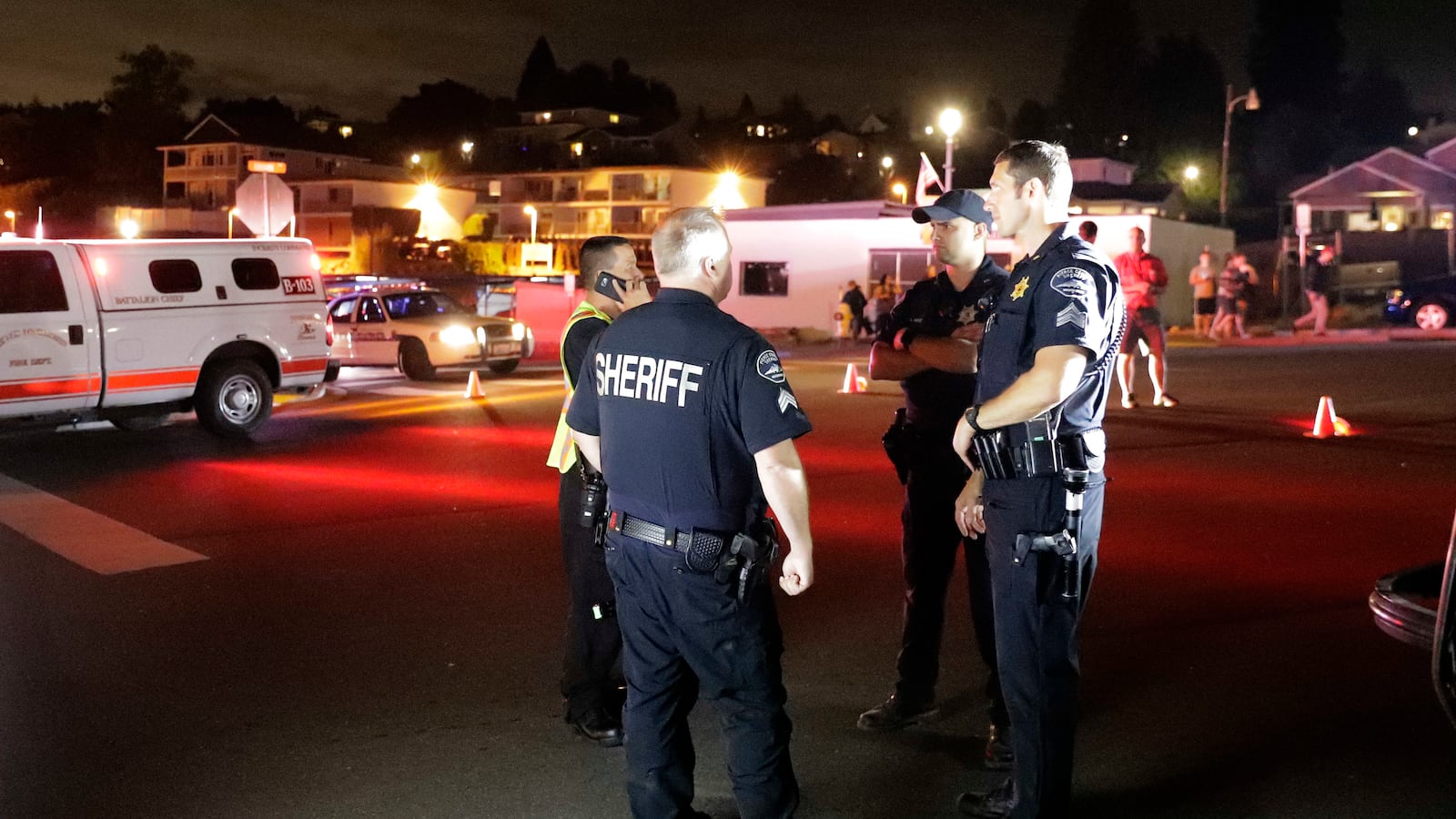 Law enforcement officials stand at a staging area, Friday, Aug. 10, 2018, at the ferry terminal in Steilacoom, Wash. after a Horizon air employee allegedly stole a plane and crashed it into an island.