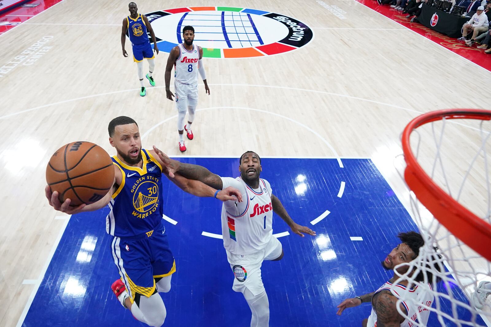 Golden State Warriors' Stephen Curry, left, goes up for a shot against Philadelphia 76ers' Andre Drummond during the first half of an NBA basketball game, Saturday, March 1, 2025, in Philadelphia. (AP Photo/Matt Slocum)