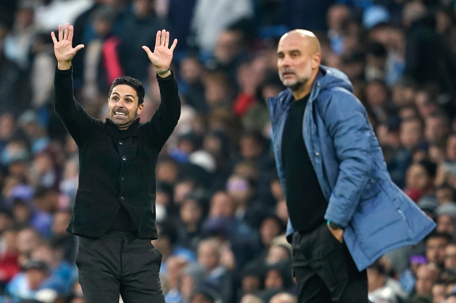 Arsenal's manager Mikel Arteta, left, gestures as he stands on the touchline next to Manchester City's head coach Pep Guardiola during the English Premier League soccer match between Manchester City and Arsenal at the Etihad stadium in Manchester, England, Sunday, Sept. 22, 2024. (AP Photo/Dave Thompson)