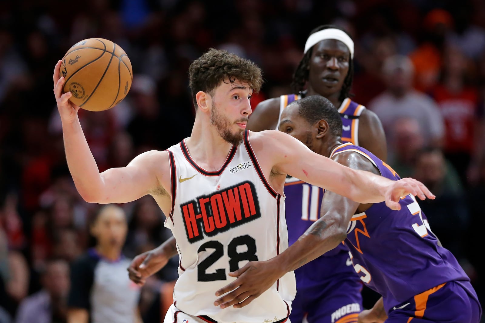 Houston Rockets center Alperen Sengun (28) is fouled while passing the ball by Phoenix Suns forward Kevin Durant, right, during the second half of an NBA basketball game Wednesday, Feb. 12, 2025, in Houston. (AP Photo/Michael Wyke)