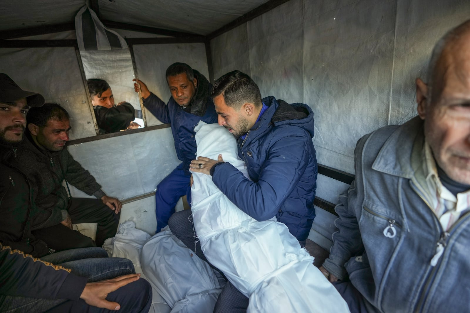 Mohammad Eid carries the body of his daughter, Dima, who was killed on Saturday along with her uncle and grandfather in an Israeli airstrike, as he prepares for her funeral in Deir al-Balah, central Gaza Strip, Sunday, Jan. 12, 2025. (AP Photo/Abdel Kareem Hana)