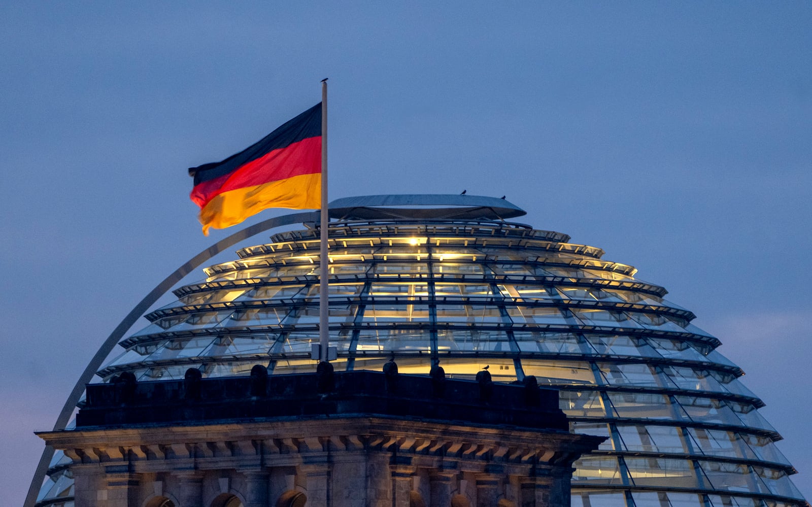 A German national flag waves on top of the Reichstag building in Berlin, Germany, Sunday, Feb. 23, 2025. (AP Photo/Michael Probst)