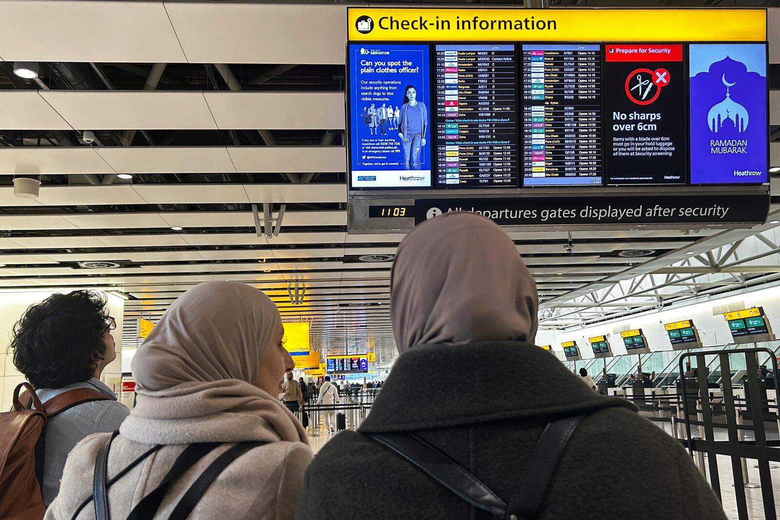 Travellers check the information board in London, Saturday, March 22, 2025, as Heathrow Airport slowly resumes flights after a fire cut power to Europe's busiest airport.(AP Photo/Kirsty Wigglesworth)