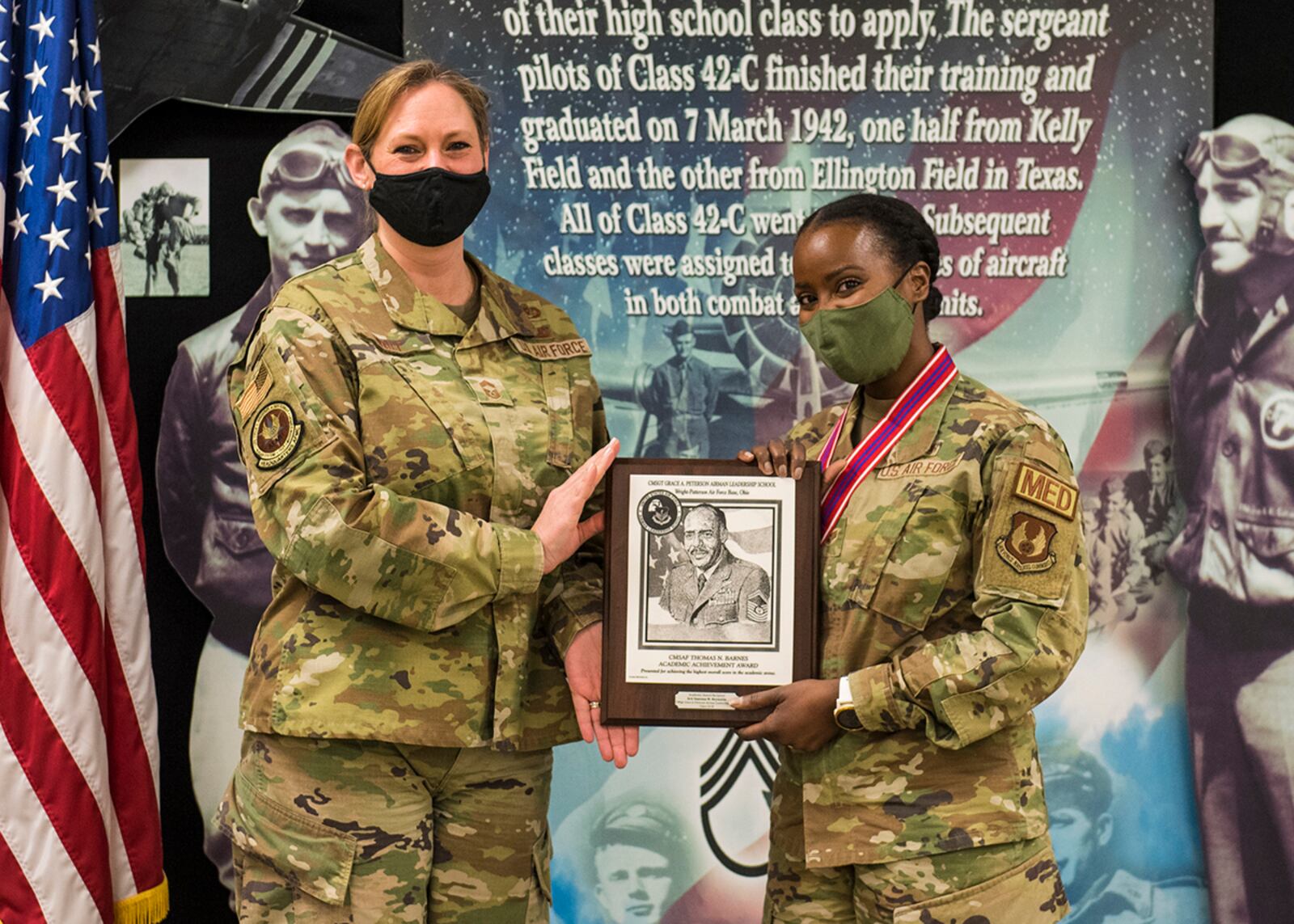 Chief Master Sgt. Lindsey Wolf (left), Air Force Materiel Command paralegal career field functional manager, presents Senior Airman Vanessa Reynolds with the Academic Achievement Award during Airman Leadership School Class 22-B’s graduation ceremony Feb. 10 at Wright-Patterson Air Force Base. Reynolds, an 88th Operational Medical Readiness Squadron technician, was also a distinguished graduate. U.S. AIR FORCE PHOTO/JAIMA FOGG