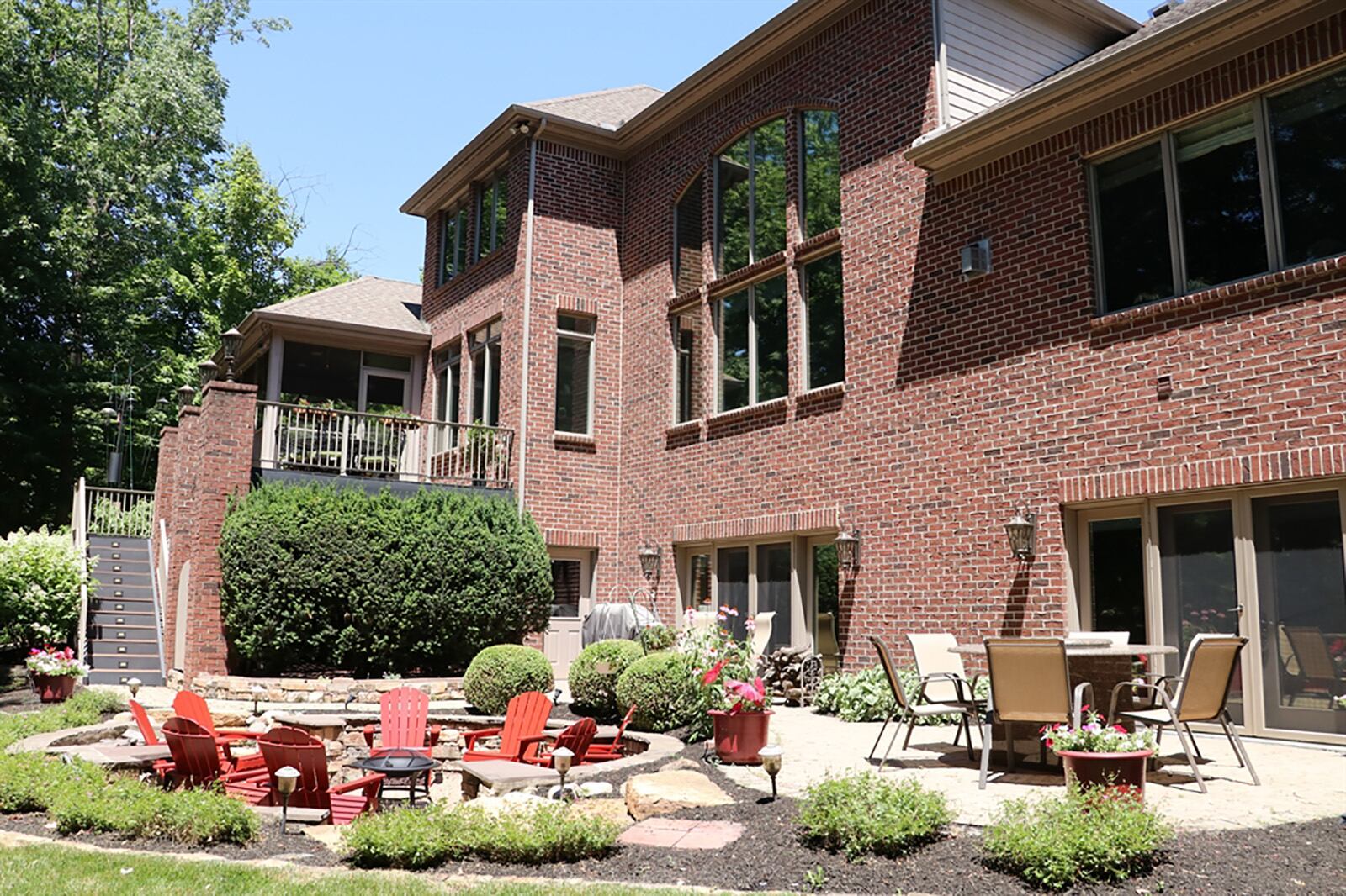 In back, the 3-season room opens to a balcony wood deck. The walk-out lower level has several daylight windows and patio doors that provide panoramic views of the backyard, paver-brick patio and sunken paver-brick fire pit area. CONTRIBUTED PHOTO BY KATHY TYLER