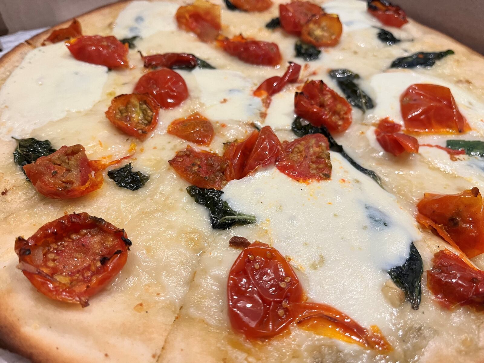 The Caprice pizza from Dewey's Pizza is a blend of olive oil, minced garlic, fontina, fresh basil, fresh mozzarella and roasted cherry tomatoes. NATALIE JONES/STAFF