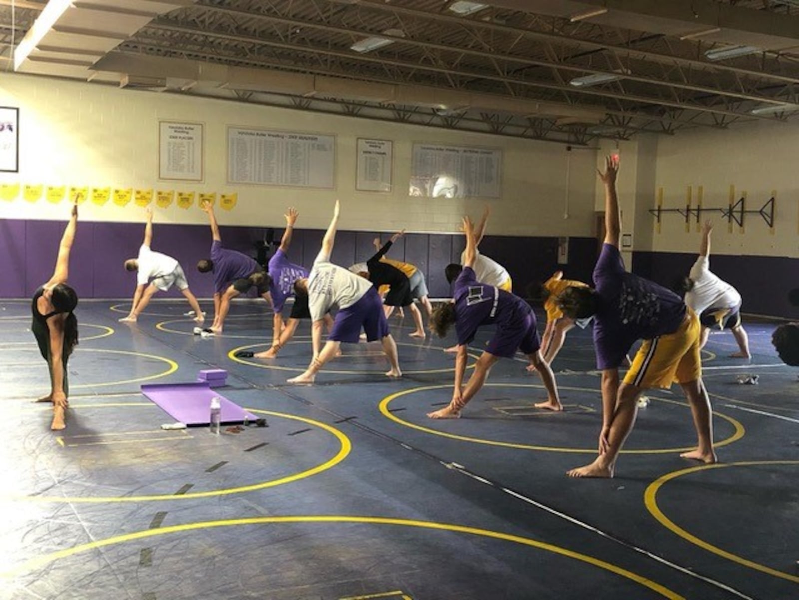 Leslie Keough (left) leading a yoga session with the Vandalia Butler football team. CONTRIBUTED