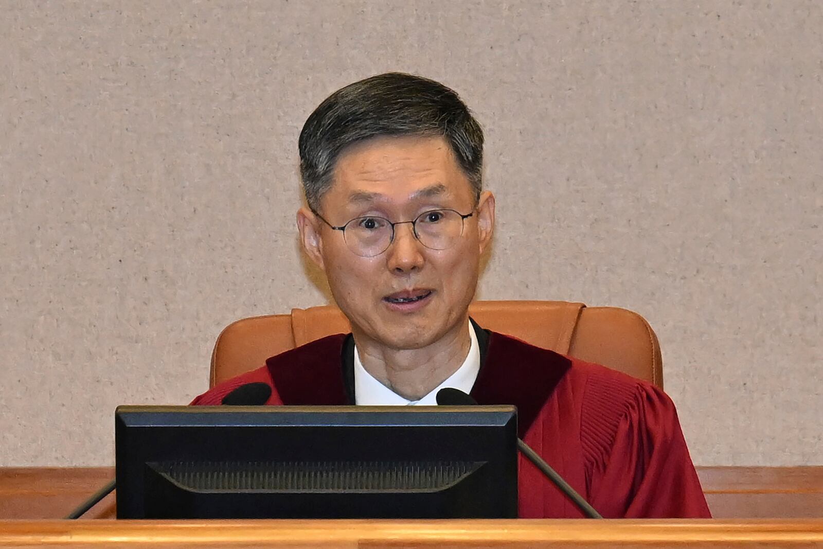 Judge Moon Hyung-bae, acting chief justice of South Korea's Constitutional Court, sits for the first formal hearing of a trial on the validity of President Yoon Suk Yeol's impeachment by the National Assembly at the constitutional court of Korea in Seoul, South Korea, Tuesday, Jan. 14, 2025. (Kim Min-Hee/Pool Photo via AP)