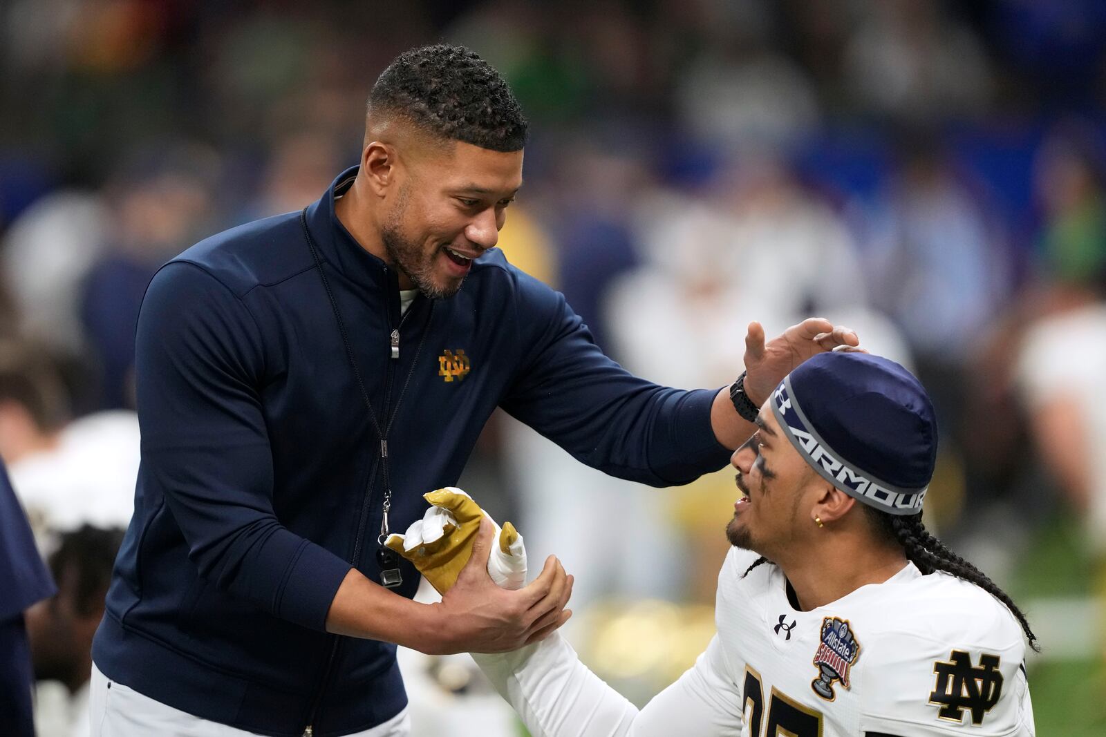 Notre Dame head coach Marcus Freeman talks with one of his players before the quarterfinals of a College Football Playoff against Georgia, Thursday, Jan. 2, 2025, in New Orleans. (AP Photo/Gerald Herbert)