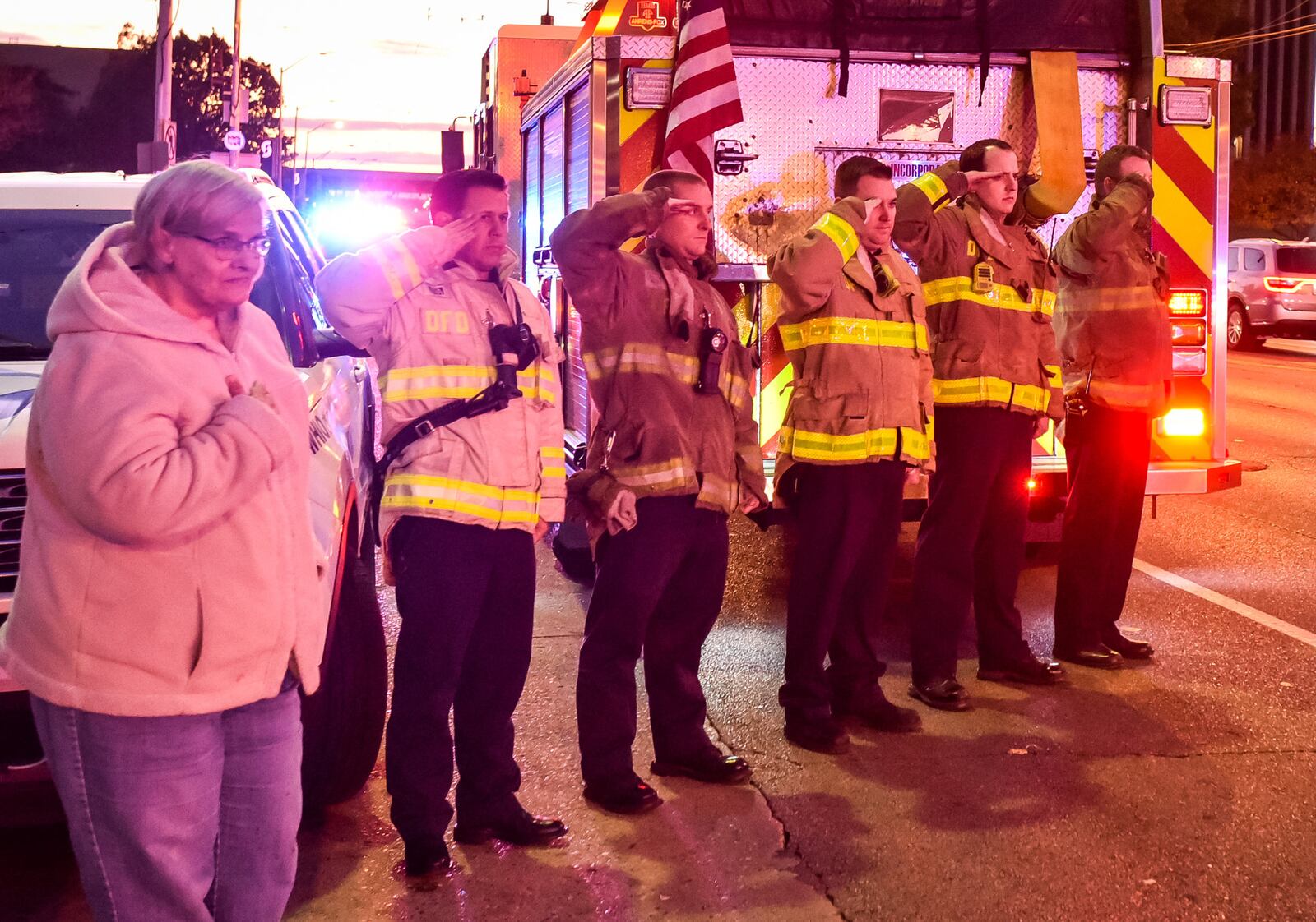 Dayton firefighters stand at attention as the procession for Dayton Police Det. Jorge Del Rio, who died Thursday after he was shot Monday night in the line of duty. Del Rio was transported from Grandview Hospital to Montgomery County Coroner's office in a Dayton. People lined the entrance along West Third Street for the processional lead by fellow Dayton police officers. NICK GRAHAM/STAFF