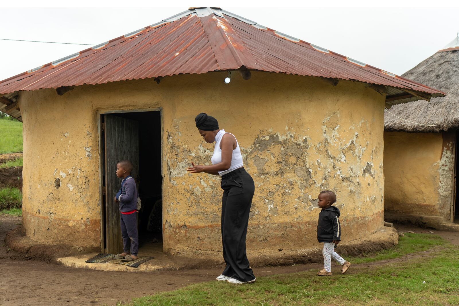 Unemployed 19-year-old South African Nozuko Majola walks with her children at her Umzimkhulu home Tuesday, Nov. 11, 2025, is one of millions of patients in South Africa affected by U.S. President Donald Trump's global foreign aid freeze, raising worries about HIV patients defaulting on treatment. (AP Photo/Jerome Delay}