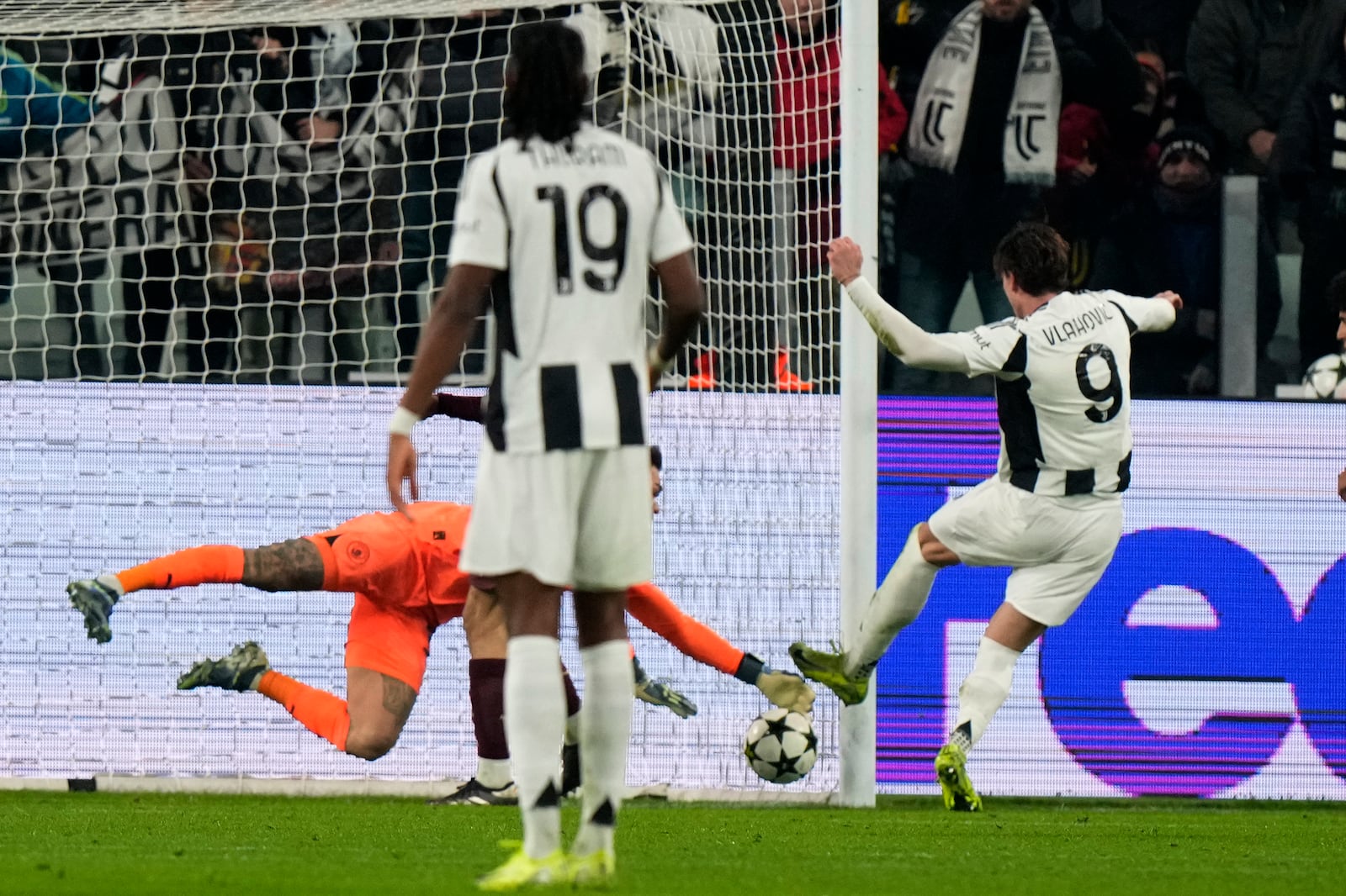 Juventus' Dusan Vlahovic, right, scores his side's first goal during the Champions League, opening phase soccer match between Juventus and Manchester City at the Allianz stadium in Turin, Italy, Tuesday, Wednesday, Dec.11, 2024. (AP Photo/Luca Bruno)