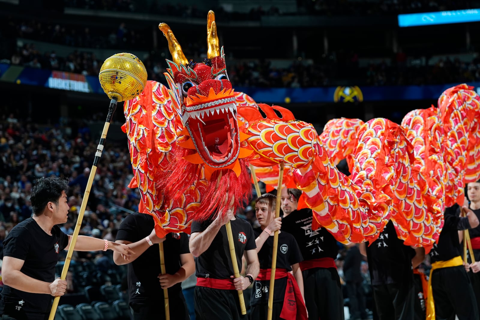 FILE - Performers carry a dragon during Lunar New Year celebrations at halftime of an NBA basketball game as the Denver Nuggets hosted the Sacramento Kings Wednesday, Feb. 14, 2024, in Denver. (AP Photo/David Zalubowski, File)