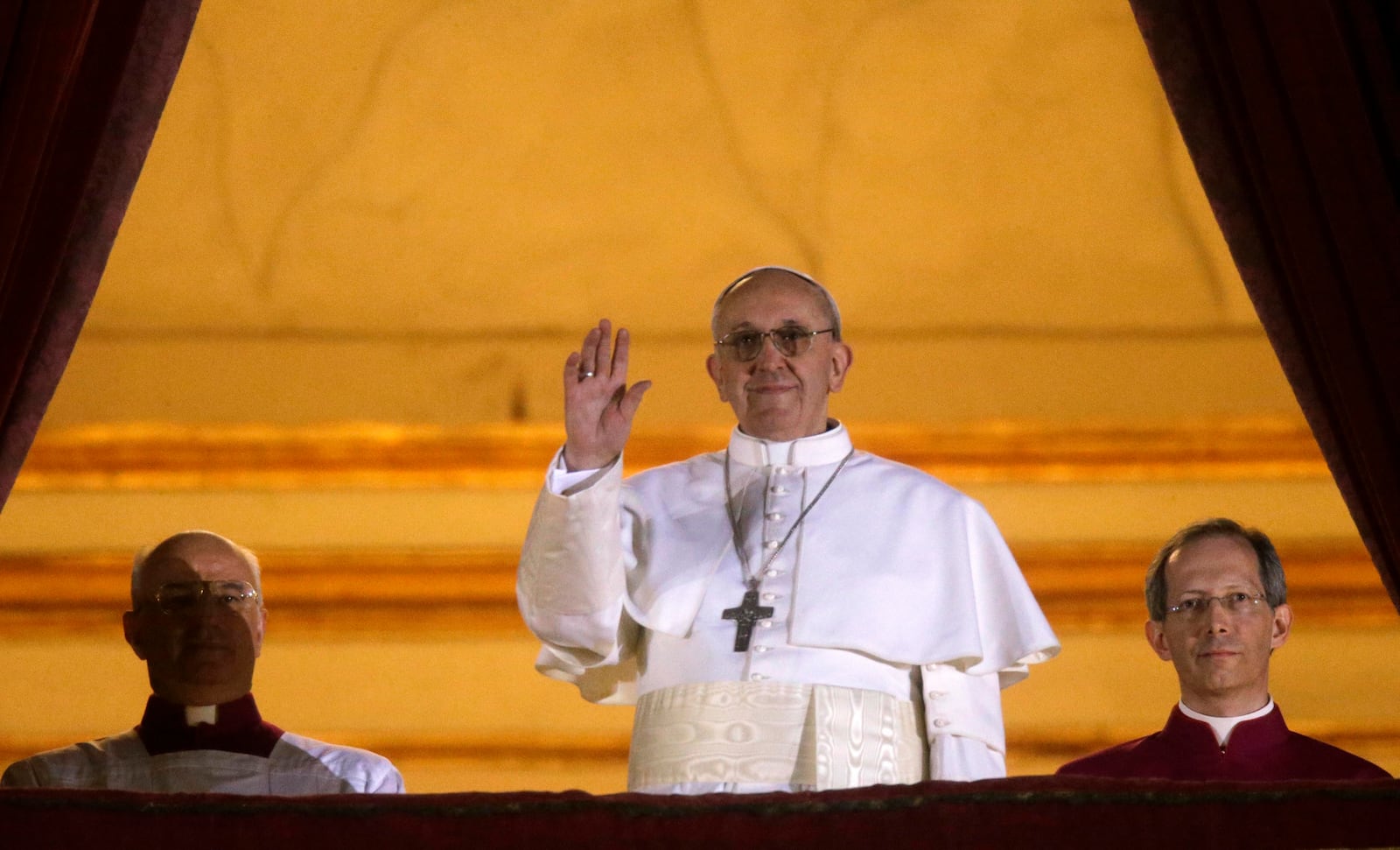 FILE - Pope Francis waves to the crowd as he appears at the central balcony of St. Peter's Basilica at The Vatican minutes after his election, March 13, 2013. (AP Photo/Gregorio Borgia, File)