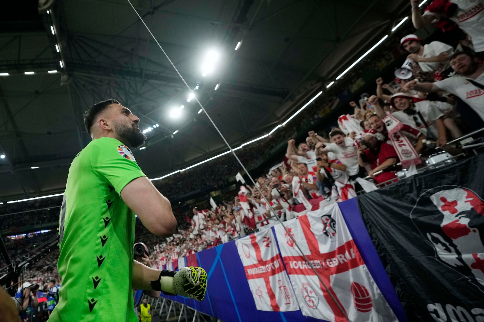 FILE - Georgia's goalkeeper Giorgi Mamardashvili celebrates with fans after a Group F match between Georgia and Portugal at the Euro 2024 soccer tournament in Gelsenkirchen, Germany, Wednesday, June 26, 2024. (AP Photo/Alessandra Tarantino, File)