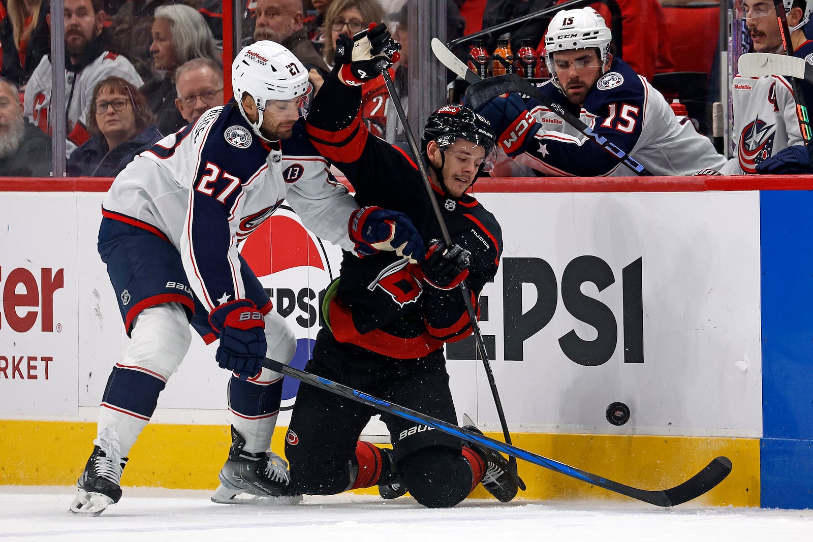 Carolina Hurricanes' Jesperi Kotkaniemi (82) battles Columbus Blue Jackets' Zachary Aston-Reese (27) for the puck during the first period of an NHL hockey game in Raleigh, N.C., Sunday, Dec. 15, 2024. (AP Photo/Karl B DeBlaker)