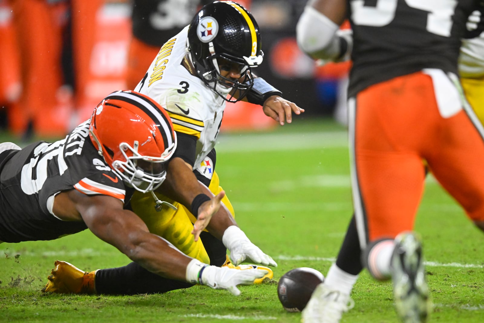 Pittsburgh Steelers quarterback Russell Wilson (3) and Cleveland Browns defensive end Myles Garrett (95) dive for a fumble in the first half of an NFL football game, Thursday, Nov. 21, 2024, in Cleveland. (AP Photo/David Richard)