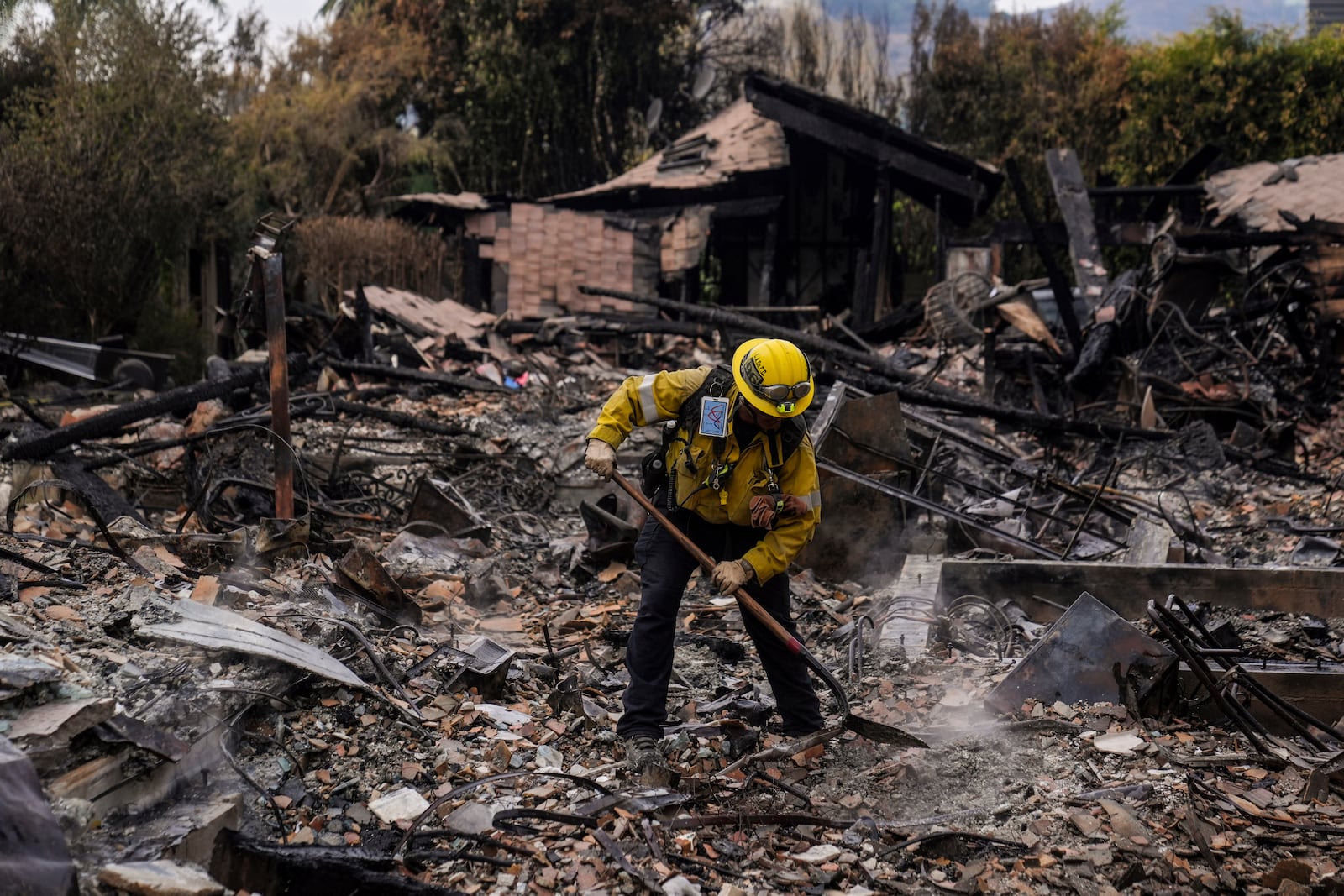 A firefighter works at a home devastated by the Franklin Fire in Malibu, Calif., Wednesday, Dec. 11, 2024. (AP Photo/Jae C. Hong)