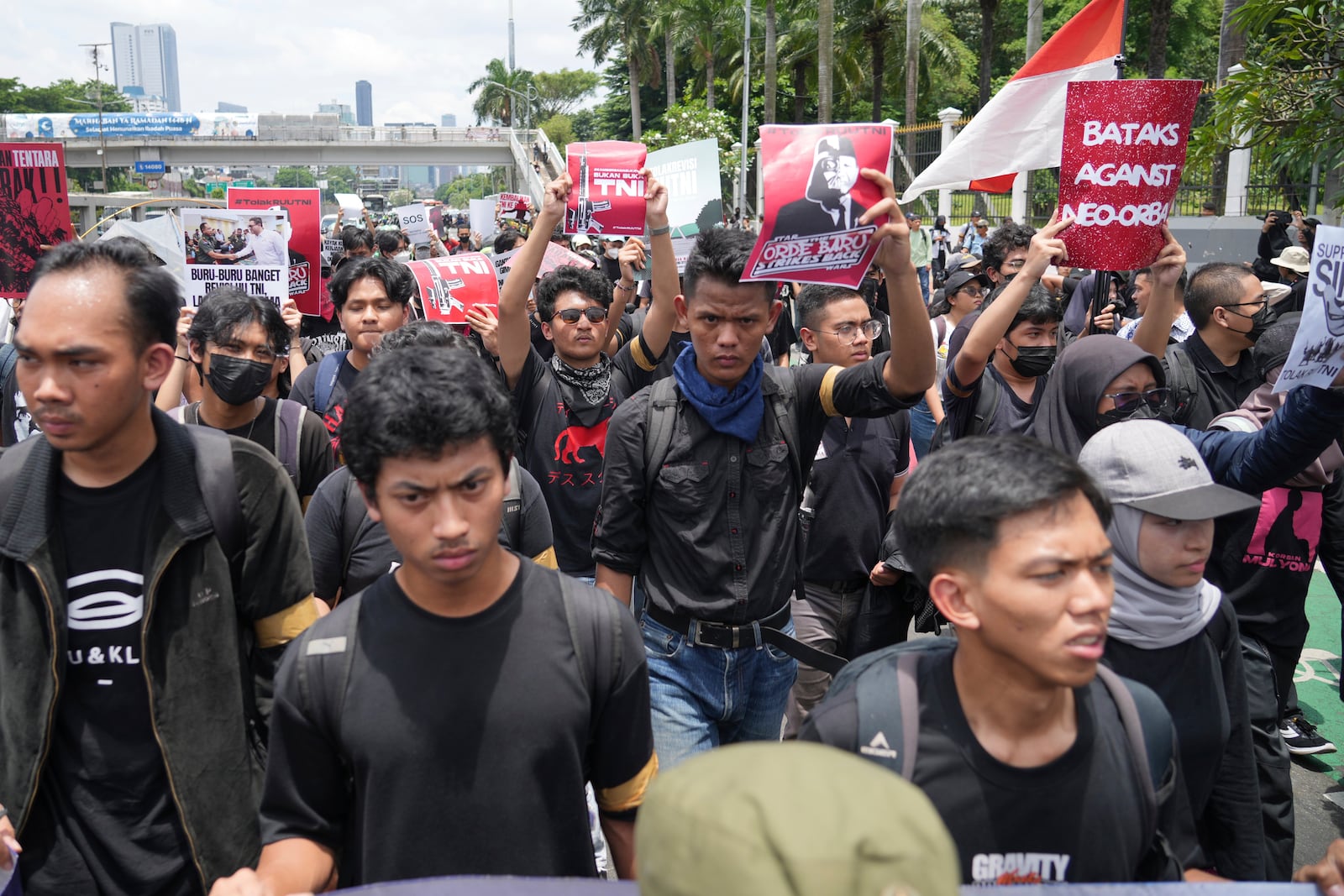 Protesters hold posters as they march during a rally against the passing of a new military law allowing active military personnel to hold more civilian posts, outside the parliament in Jakarta, Indonesia, Thursday, March 20, 2025. (AP Photo/Tatan Syuflana)