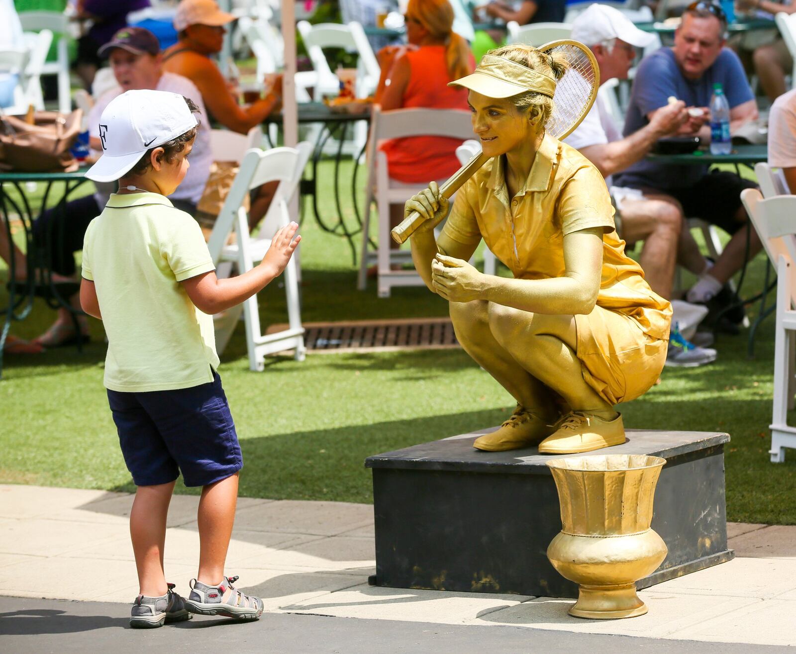 Lexi Perrmann of the Cincinnati Circus, posed as a statue with fans last year, on the grounds of the Western and Southern Open, held at the Lindner Family Tennis Center in Mason. GREG LYNCH / STAFF