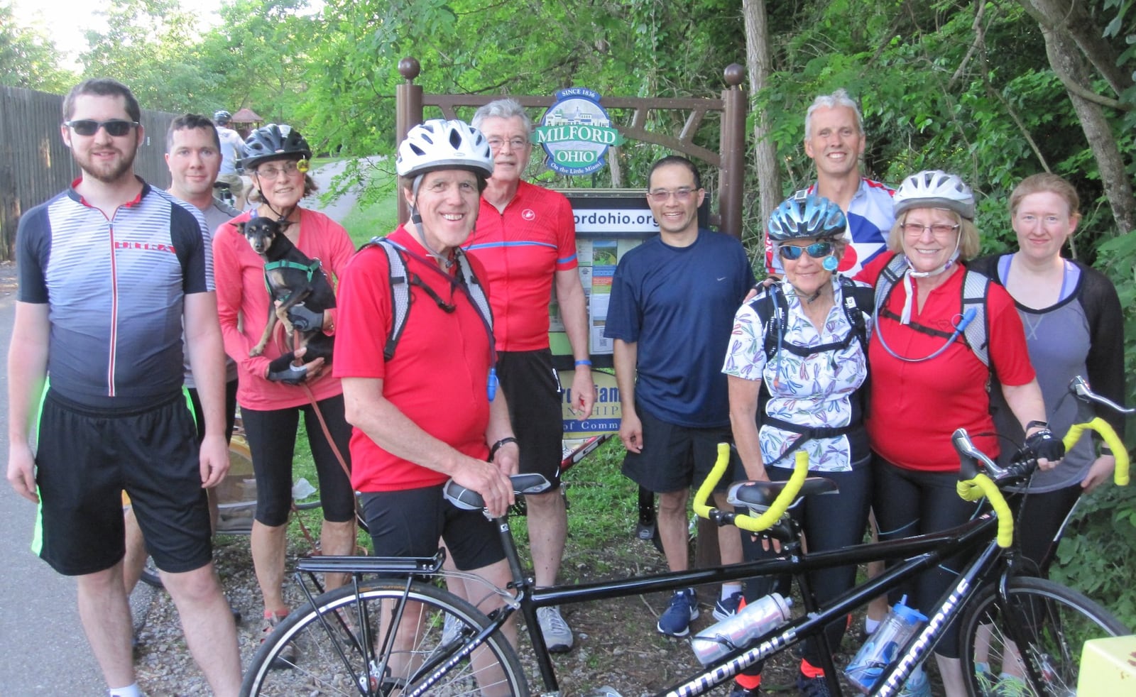 Cyclists who completed the 100 miles at the finish line in Milford with Melody Morris and Bill Nance (red shirts, white helmets) last year. CONTRIBUTED