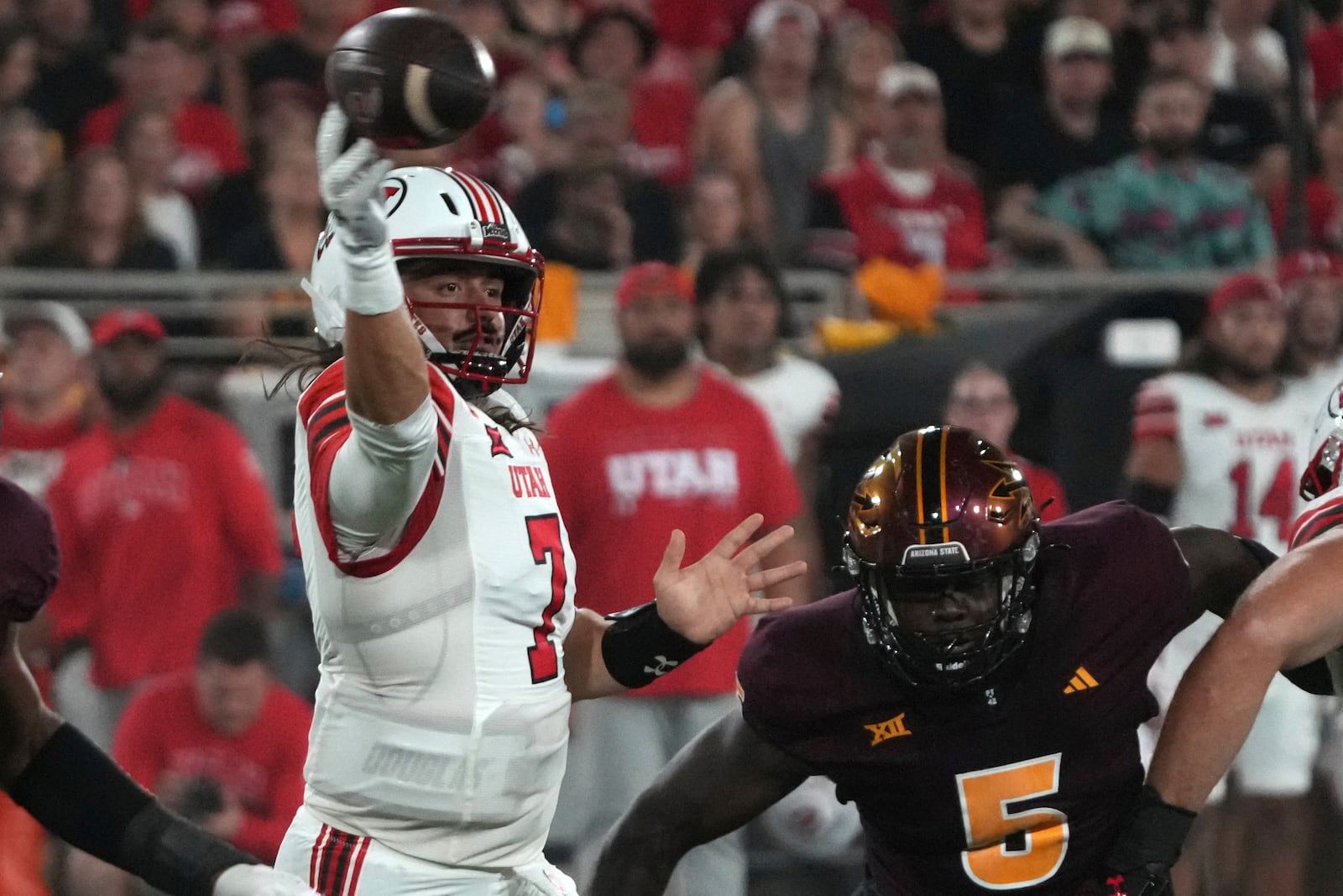 Utah quarterback Cameron Rising throws down field away from Arizona State defensive lineman Jeff Clark in the first half during an NCAA college football game, Friday, Oct. 11, 2024, in Tempe, Ariz. (AP Photo/Rick Scuteri)