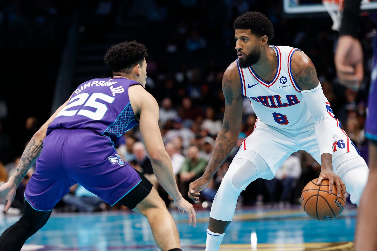 Philadelphia 76ers forward Paul George (8) runs the offense against Charlotte Hornets guard KJ Simpson during the second half of an NBA Cup basketball game in Charlotte, N.C., Tuesday, Dec. 3, 2024. (AP Photo/Nell Redmond)