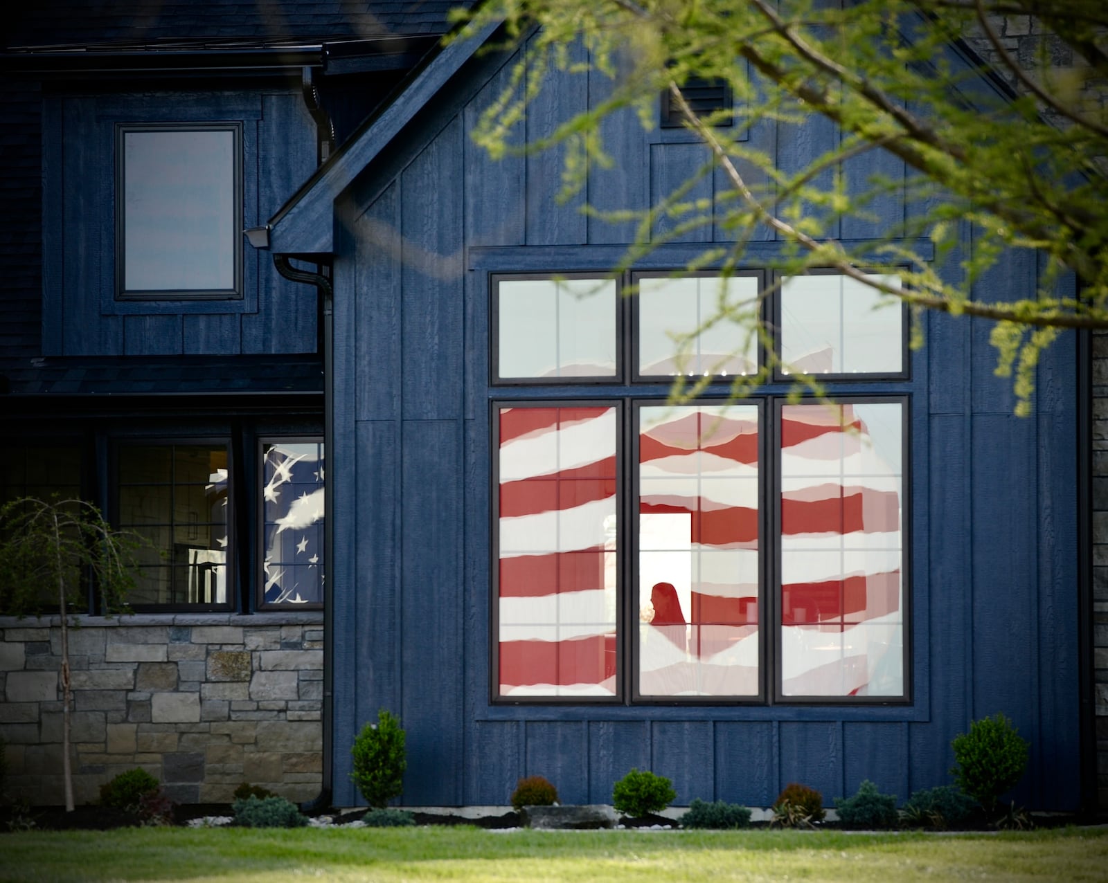 A home dedication ceremony was held Friday, April 26, 2024 outside Lebanon for U.S. Navy Petty Officer First Class (Ret.) John Kremer. This home was donated by the Gary Sinise Foundation and built in partnership with Brandon Homes. A large American flag is reflected in the front window of the home. MARSHALL GORBY\STAFF