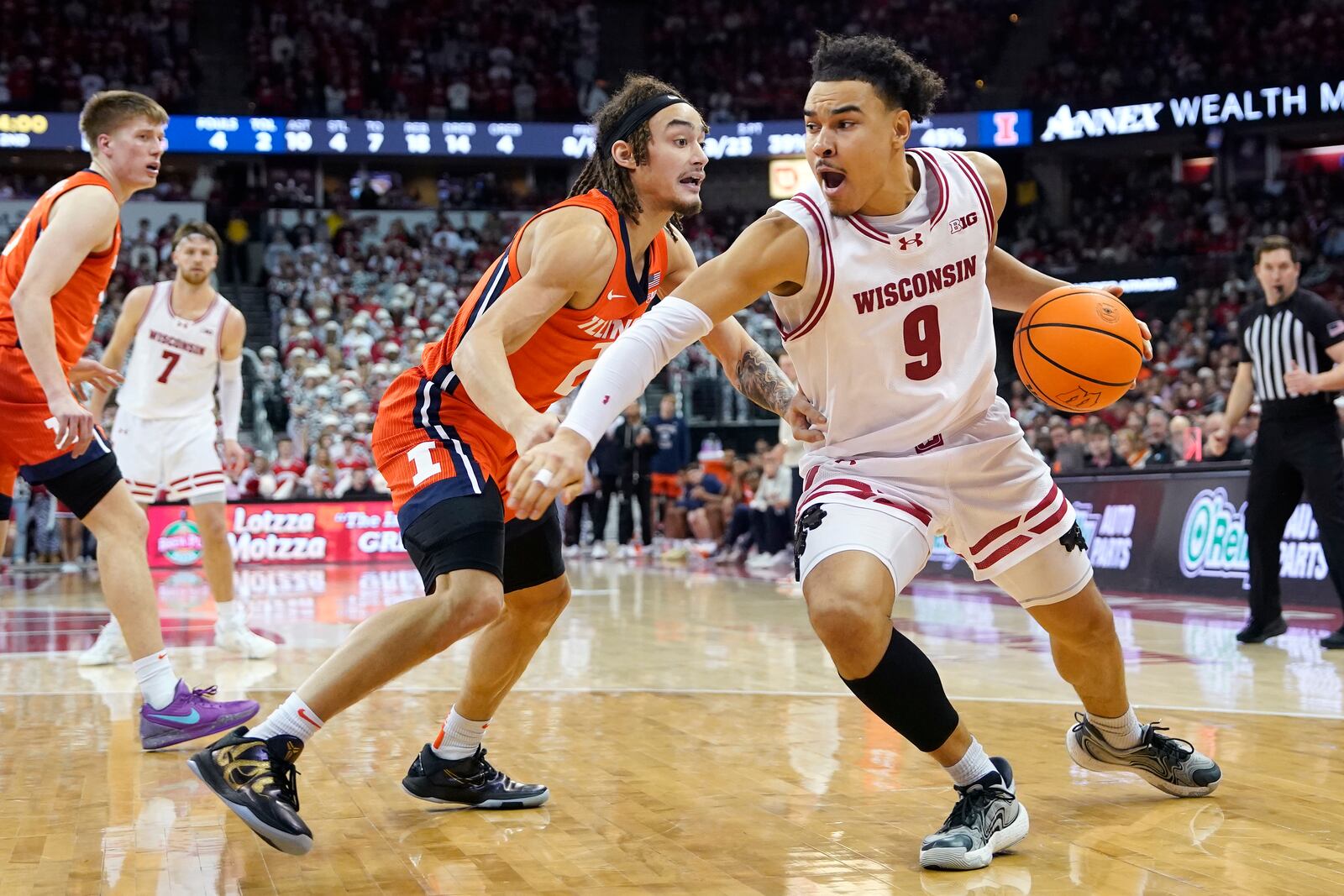 Wisconsin guard John Tonje (9) handles the ball against Illinois guard Dra Gibbs-Lawhorn during the second half of an NCAA college basketball game, Tuesday, Feb. 18, 2025, in Madison, Wis. (AP Photo/Kayla Wolf)