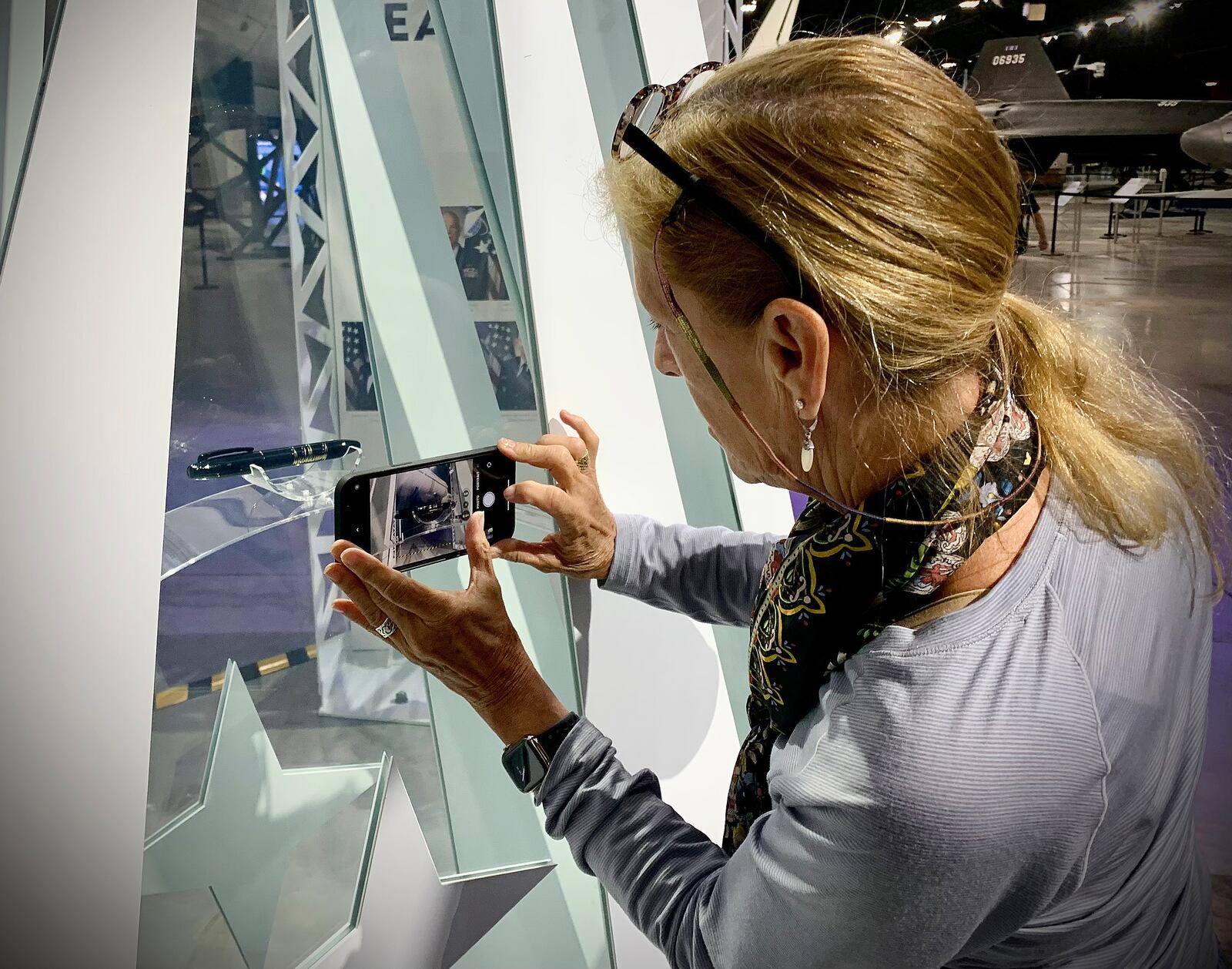 Anne Spencer of Chicago photographs the pen former President Donald Trump used to sign in the newest branch of the American armed forces, the U.S. Space Force is on display at the National Museum.  MARSHALL GORBY\STAFF