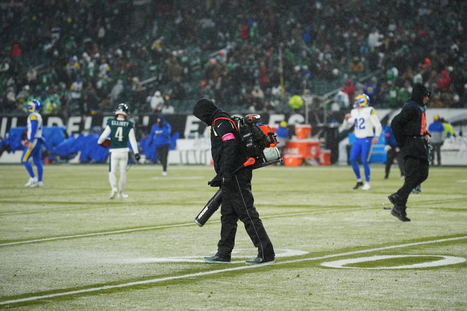 Snow is cleared as the first half ends of an NFL football NFC divisional playoff game between the Philadelphia Eagles and the Los Angeles Rams on Sunday, Jan. 19, 2025, in Philadelphia. (AP Photo/Matt Slocum)