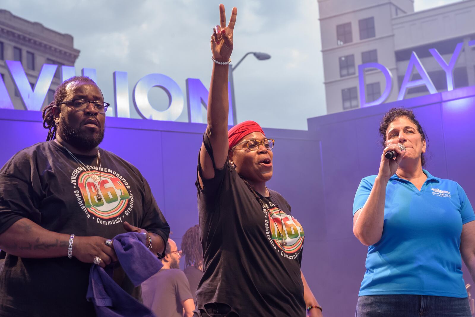 (left to right) Robert N. Owens of Signature Educational Solutions, Sierra Leone of Signature Educational Solutions, and Lisa Wagner of Levitt Pavilion Dayton address patrons at the Juneteenth Commemoration, Celebration and Community Concert at Levitt Pavilion in downtown Dayton on Saturday, June 19, 2021. TOM GILLIAM / CONTRIBUTING PHOTOGRAPHER