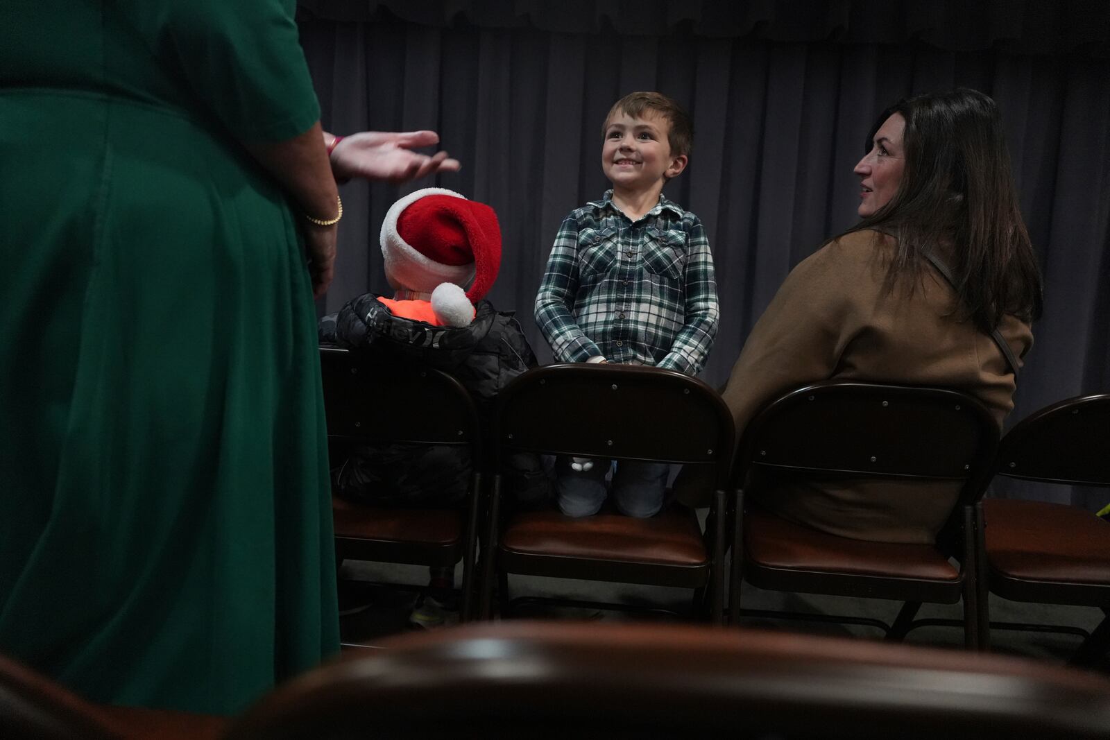 A boy waits for the start of the community putz, a Moravian tradition that retells the story of Christ’s birth with miniature wooden figurines, music and narration, in Bethlehem, Pa., on Sunday, Dec. 1, 2024. (AP Photo/Luis Andres Henao)