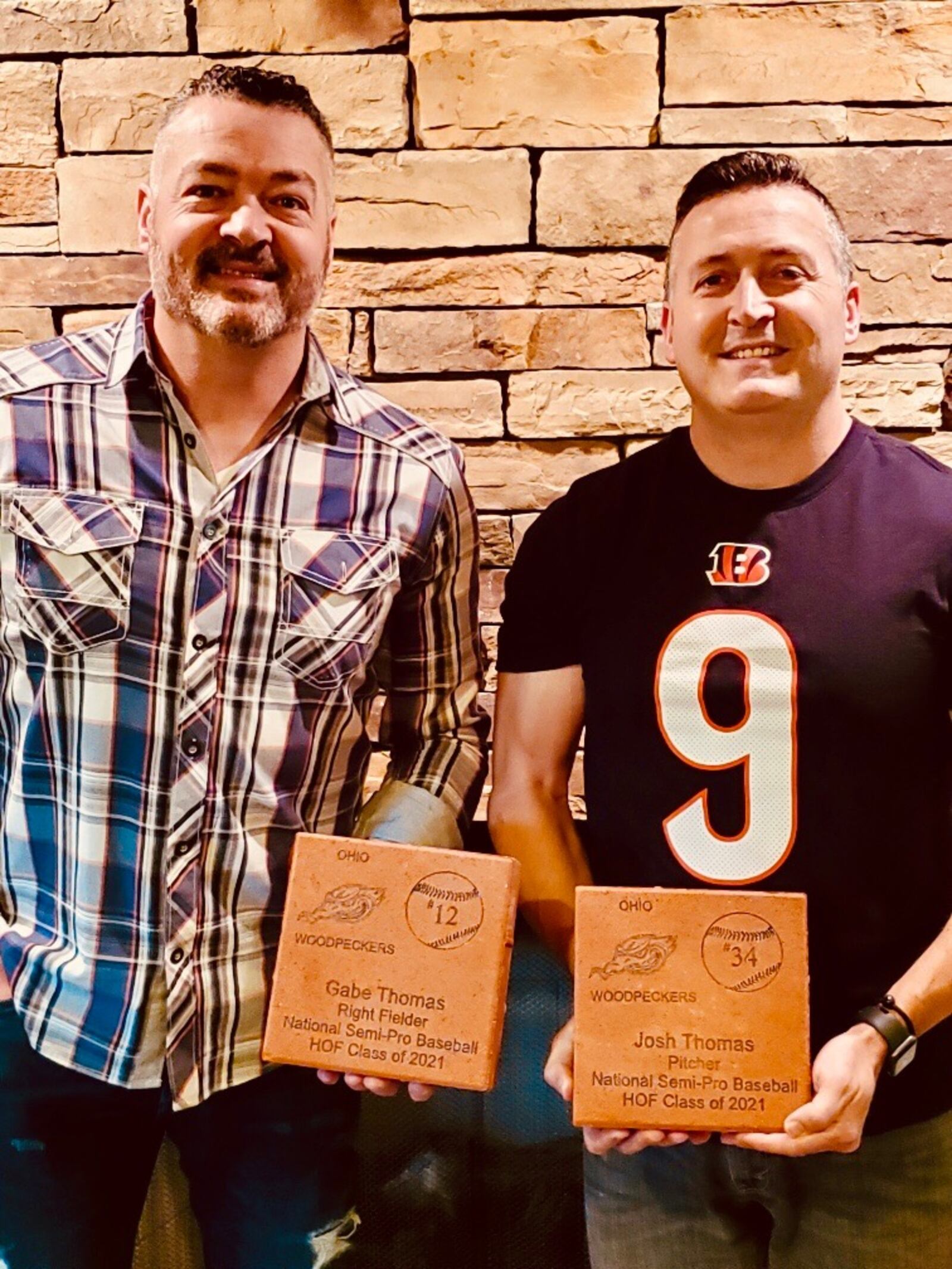 Gabe Thomas, left, and his brother Josh Thomas hold their bricks after induction into the Semi-Pro Baseball Hall of Fame in Evansville, Ind., on Oct. 10, 2021.