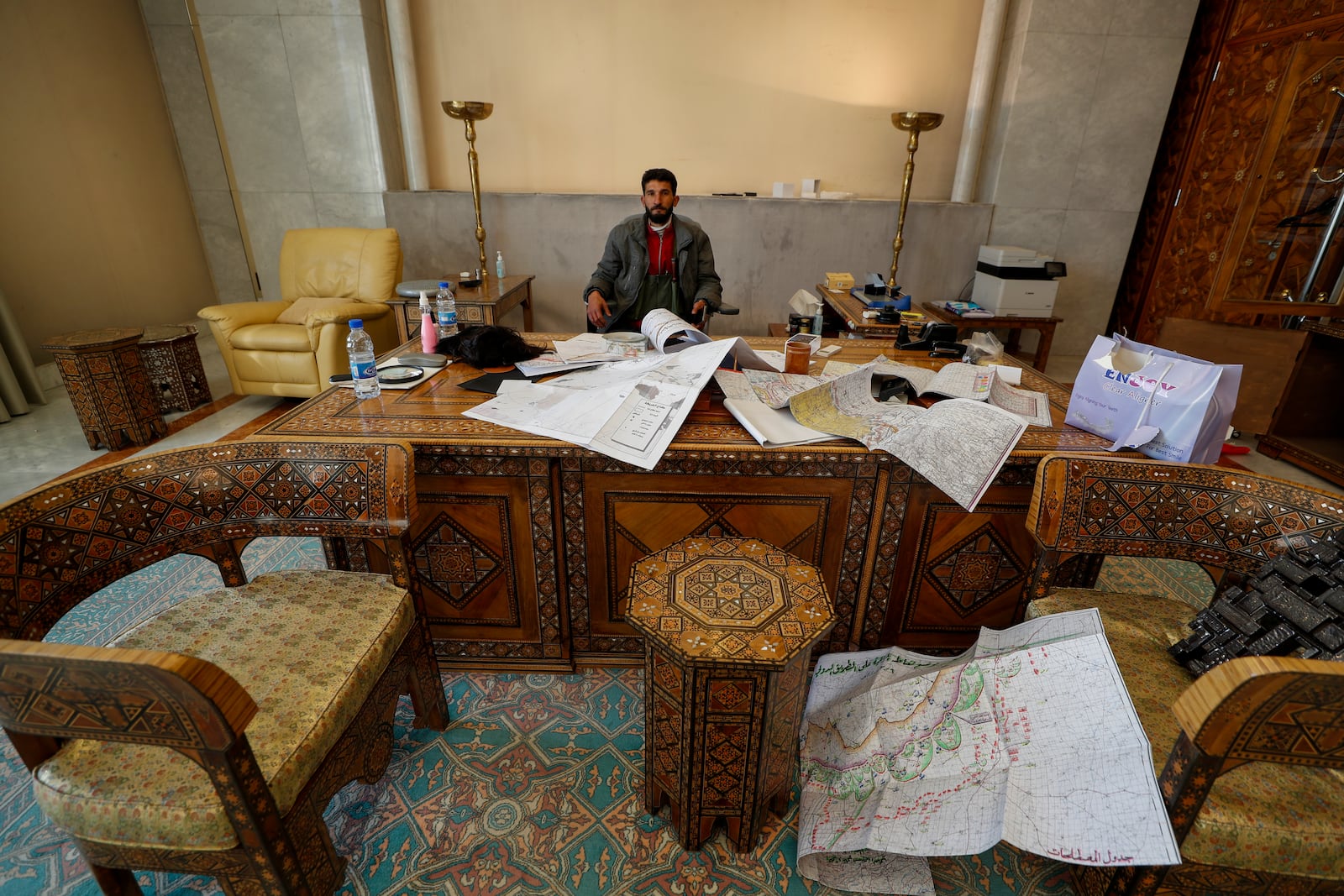 FILE - A Syrian opposition fighter sits inside an office at the Presidential Palace after the Syrian government collapsed in Damascus, Syria, on Sunday, Dec. 8, 2024. (AP Photo/Omar Sanadiki, File)