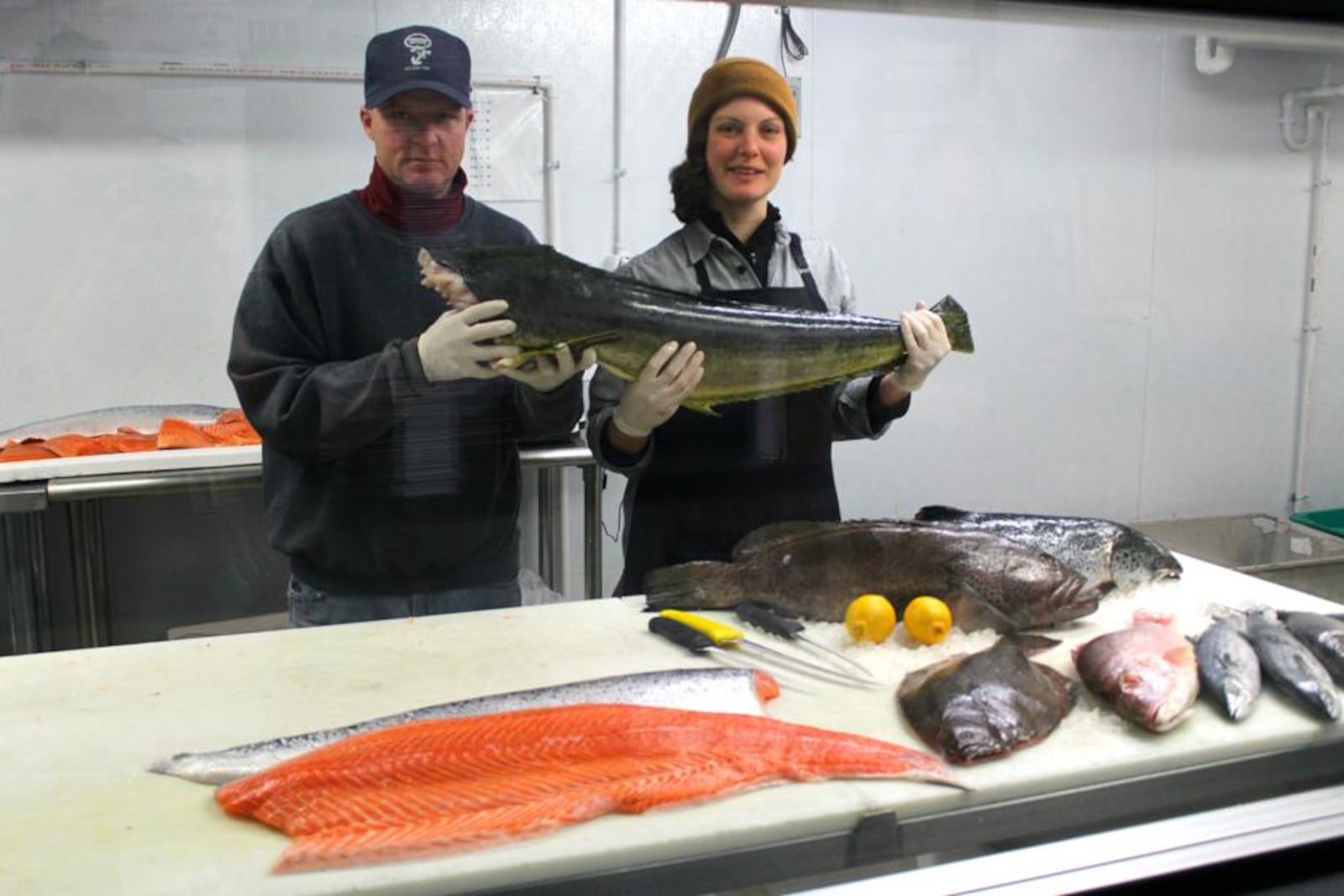 Foremost Seafood employees Tony Coletta and Carmen Rasdal hold up a Mahi Mahi fish in the back cooler at 1904 Woodman Dr. in Kettering. The market is popular with professional chefs and home cooks. VIVIENNE MACHI / STAFF