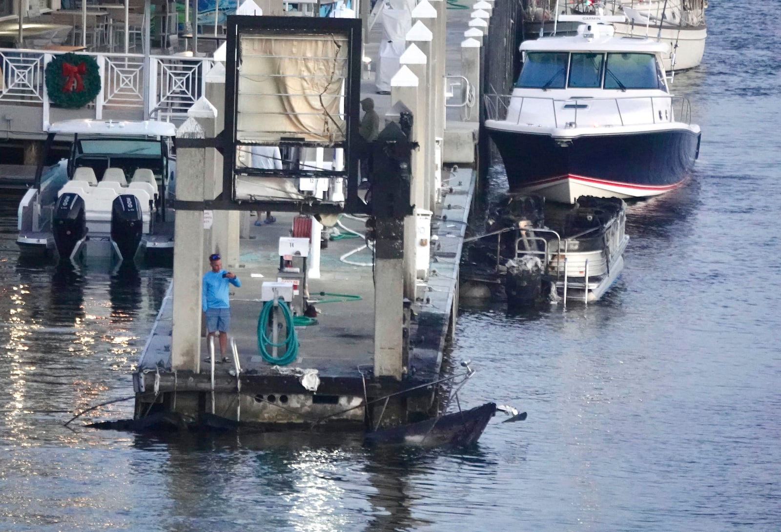 The charred remains of two boats are seen Tuesday, Dec. 24, 2024, at Lauderdale Marina near the 15th Street Fisheries restaurant in Fort Lauderdale, Fla. (Joe Cavaretta/South Florida Sun-Sentinel via AP)