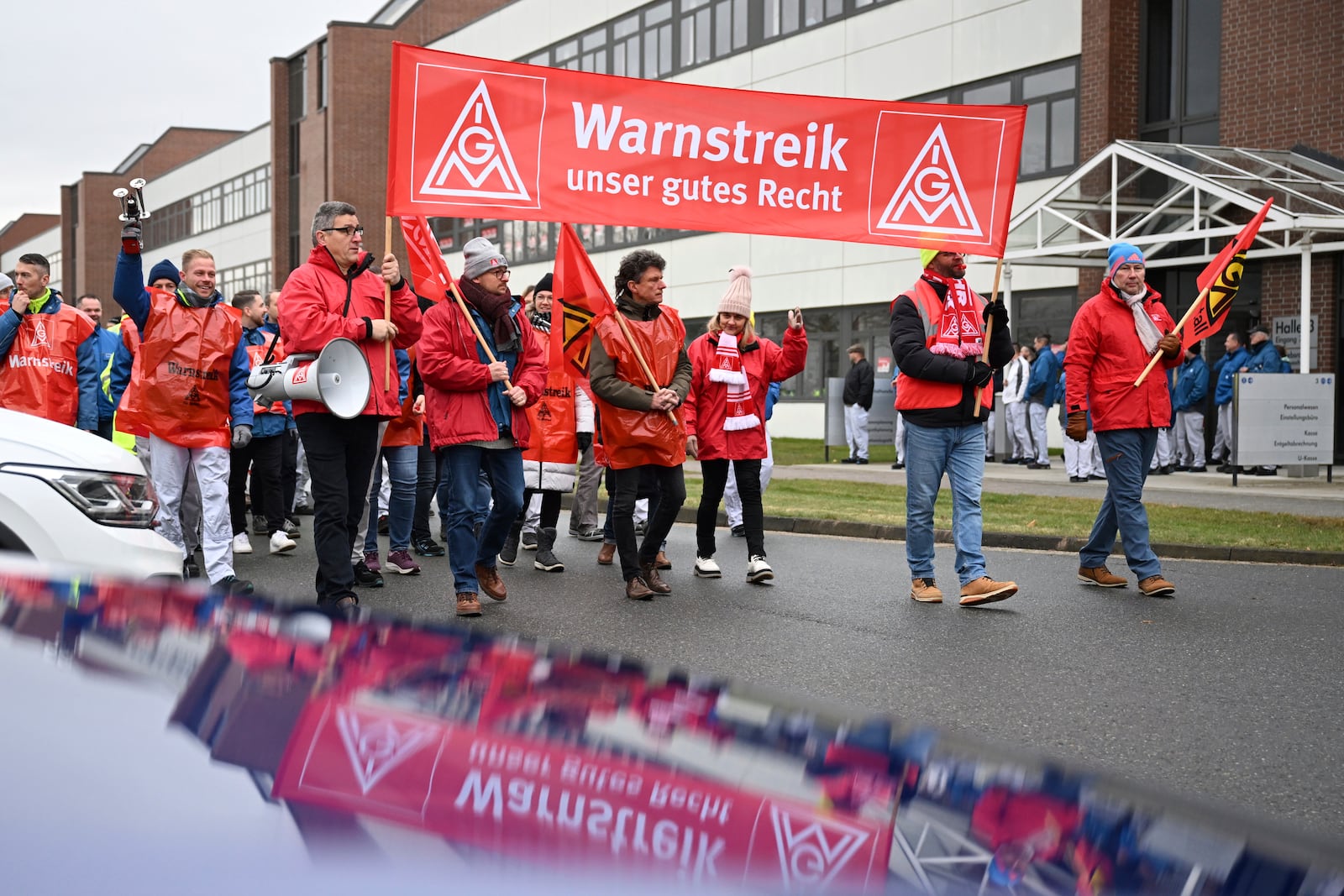 Volkswagen workers march holding a sign with writing reading in German "Warning strike is our right" on the first day of a nationwide warning Volkswagen workers' strike, in Zwickau, Germany, Monday, Dec. 2, 2024. (Hendrik Schmidt/dpa via AP)