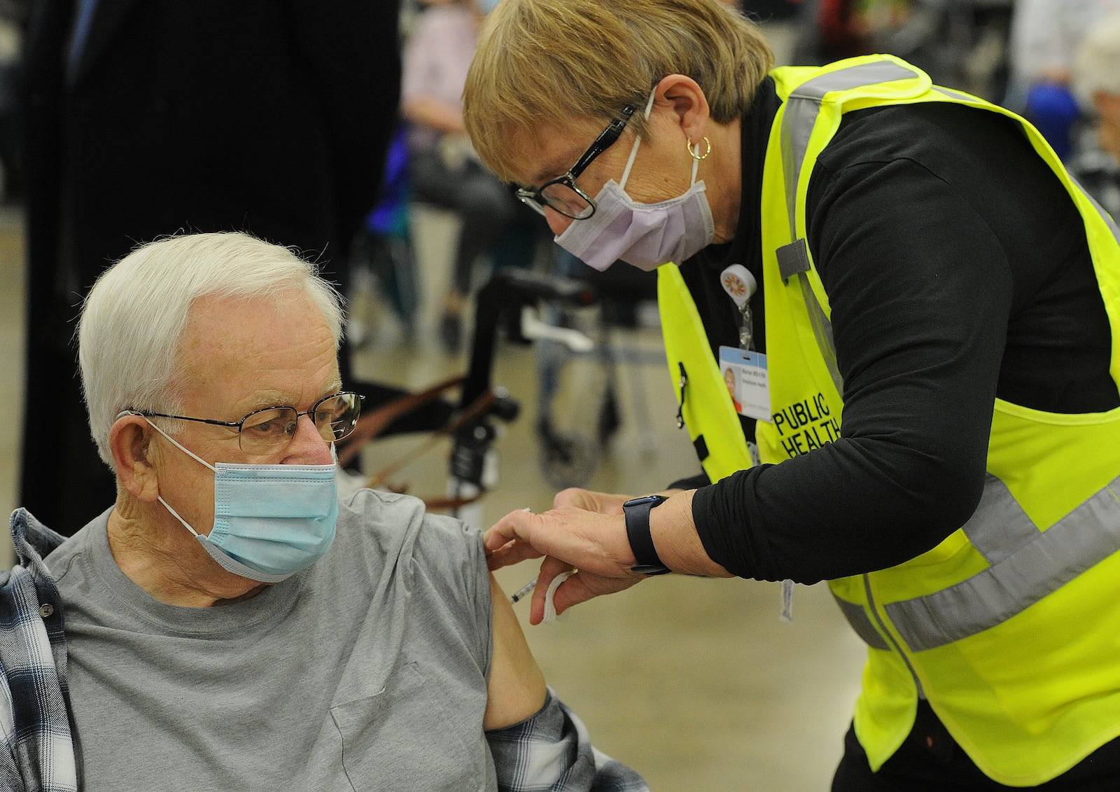 Michael Whitesell, 81, of Englewood, receives his COVID-19 vaccination from a healthcare worker Wednesday morning, Jan. 20, 2021 at the Dayton Convention Center. MARSHALL GORBY\STAFF