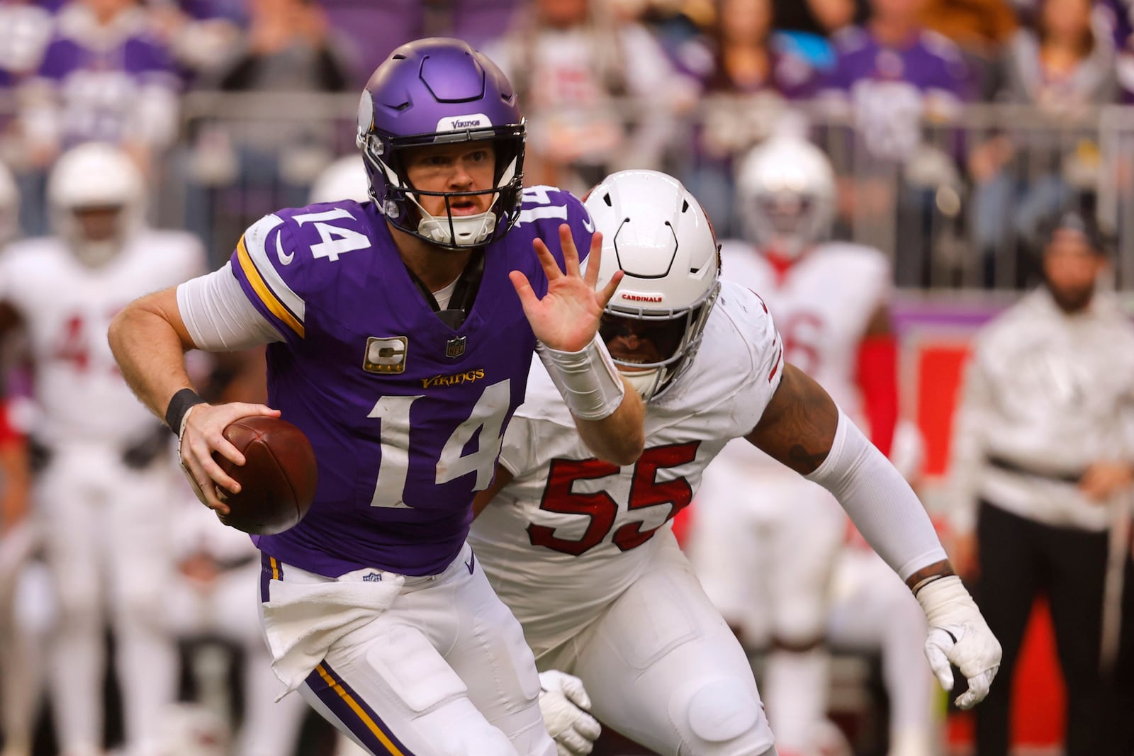 Minnesota Vikings quarterback Sam Darnold (14) runs from Arizona Cardinals defensive tackle Dante Stills (55) during the second half of an NFL football game Sunday, Dec. 1, 2024, in Minneapolis. (AP Photo/Bruce Kluckhohn)