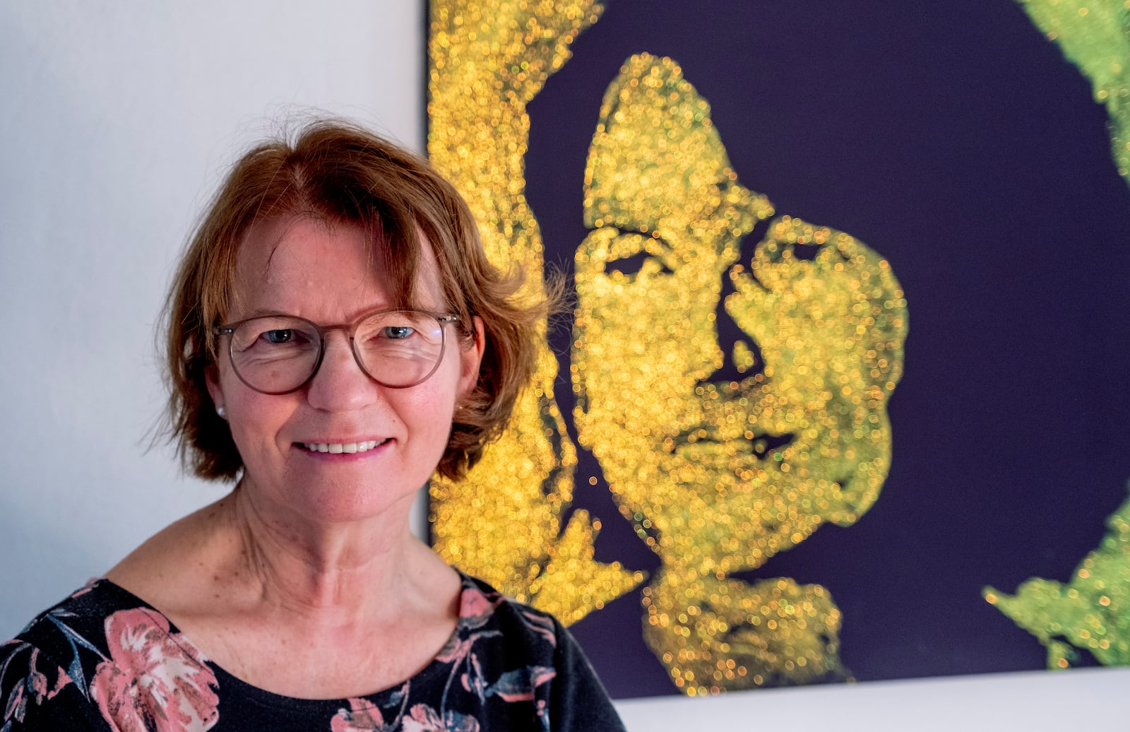 Claudia Huth poses next to a painting showing herself and painted by her son in her house in Egelsbach, Germany, Thursday, Oct. 31, 2024. (AP Photo/Michael Probst)