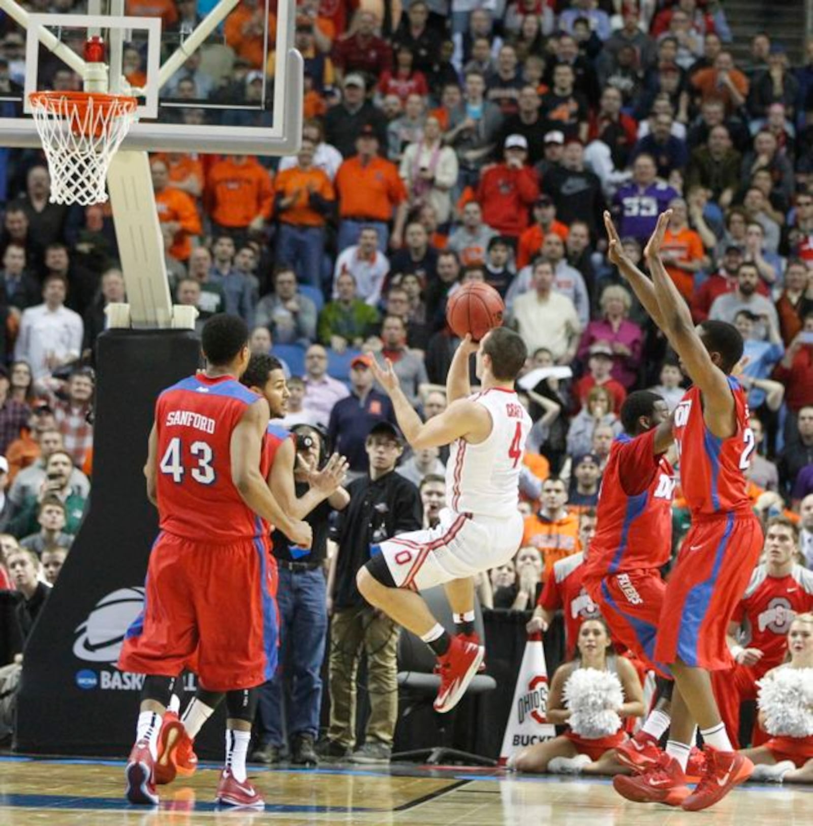 Ohio State guard Aaron Craft misses a shot at the final buzzer as he's guarded by (clockwise from front left) Dayton's Vee Sanford, Devin Oliver, Khari Price and Dyshawn Pierre in the second round of the NCAA tournament on Thursday, March 20, 2014, at the First Niagara Center in Buffalo, N.Y.