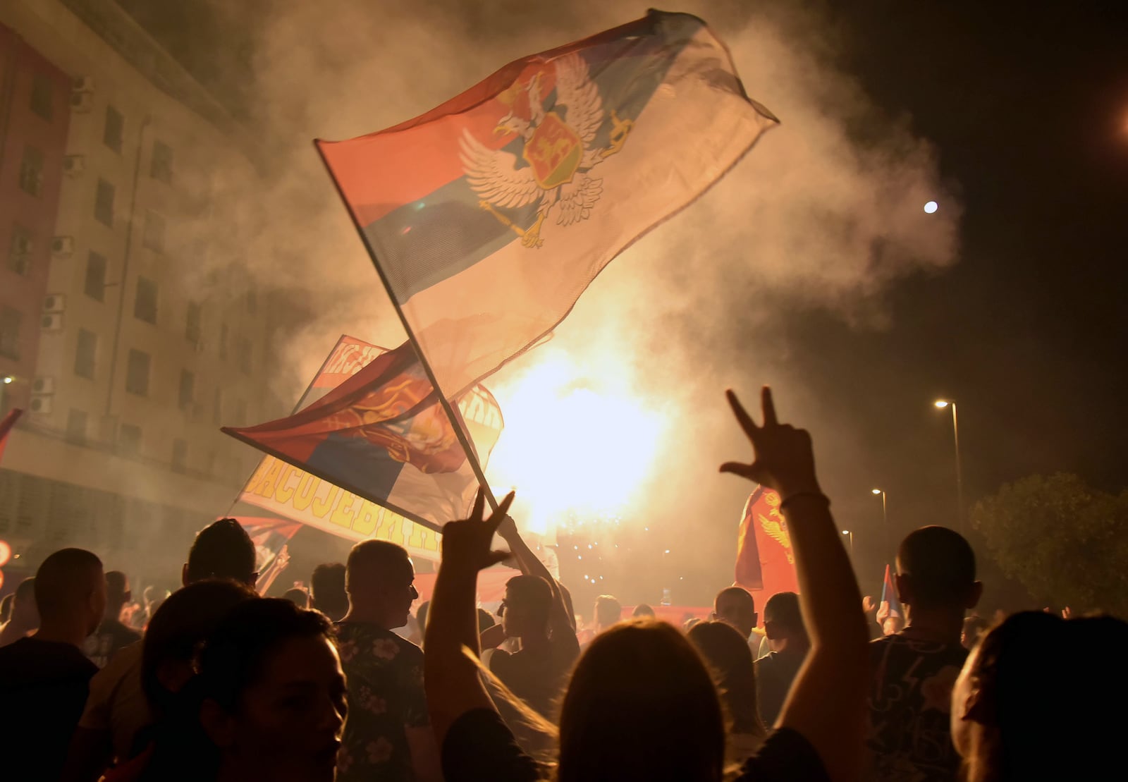 In this photo taken early Monday, Aug. 31, 2020, supporters of opposition groups celebrate after declaring victory in Montenegro's parliamentary elections in Podgorica, Montenegro. The leaders of the three main opposition groups in Montenegro signed a coalition agreement Wednesday to form the next government as they tried to alleviate fears that under the new leadership, the small Balkan state will drift away from its pro-Western course and move back closer to Serbia and Russia. (AP Photo/Risto Bozovic)