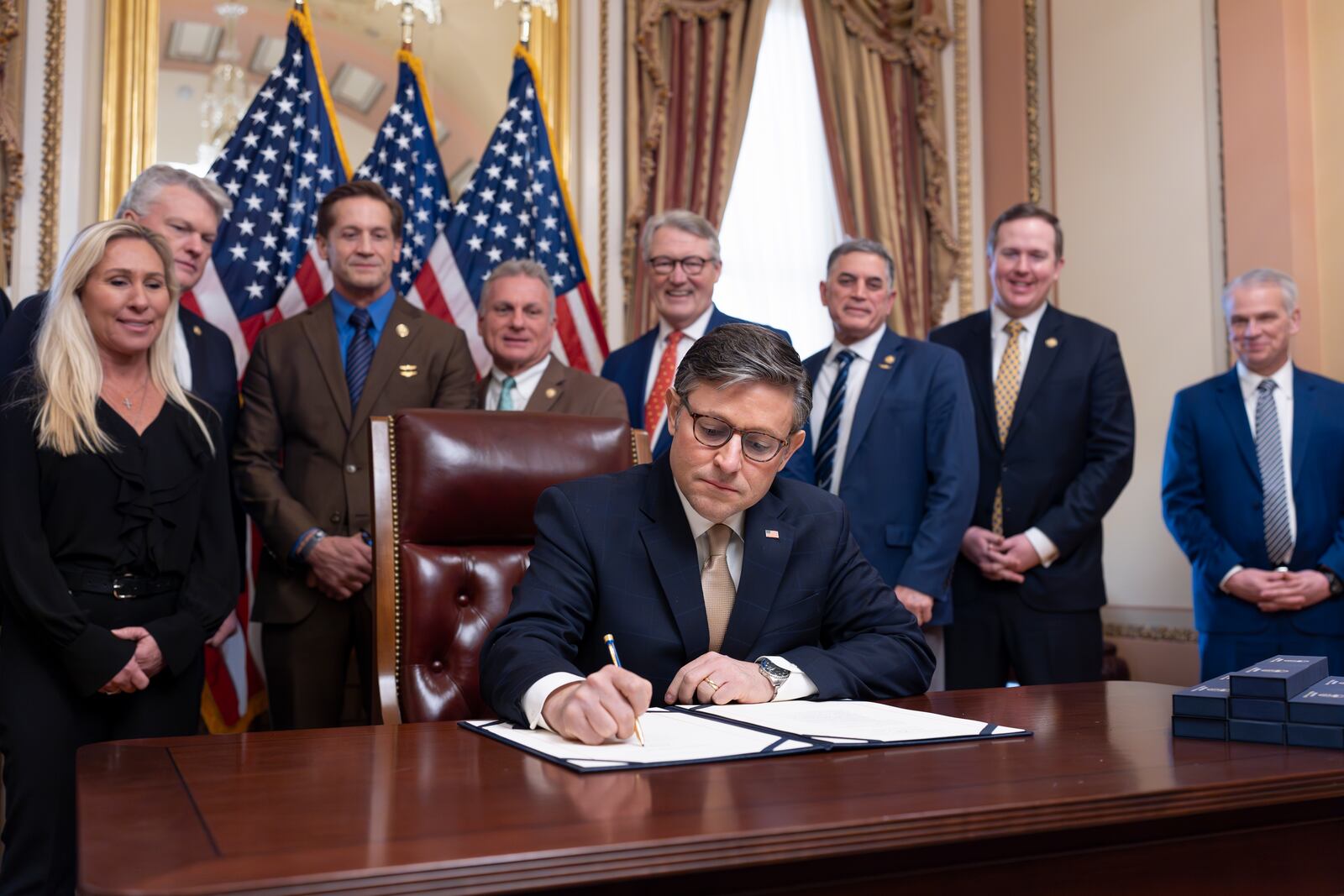 House Speaker Mike Johnson, R-La., puts his signature on the Laken Riley Act with members of the Georgia congressional delegation attending, at the Capitol in Washington, Thursday, Jan. 23, 2025. (AP Photo/J. Scott Applewhite)