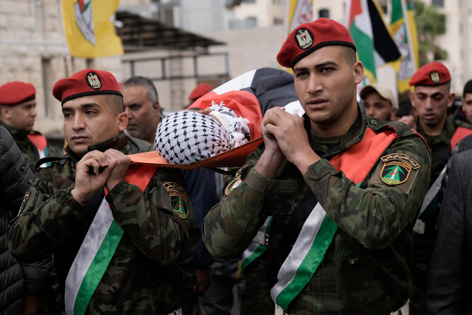 Palestinian honor guards carry the body of Nour Arafat, 18, killed in clashes by an Israeli soldier Monday and claimed by Hamas as one of its militant fighters, during his funeral in the West Bank city of Nablus, Tuesday, Nov. 19, 2024. (AP Photo/Majdi Mohammed)