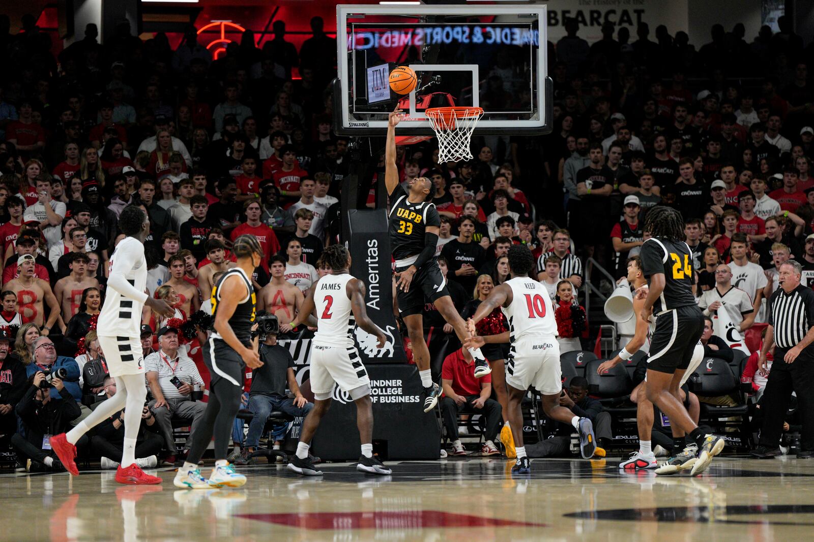 Arkansas-Pine Bluff guard Quentin Bolton (33) shoots against Cincinnati's Jizzle James (2) and Josh Reed (10) during the first half of an NCAA college basketball game, Monday, Nov. 4, 2024, in Cincinnati. (AP Photo/Jeff Dean)