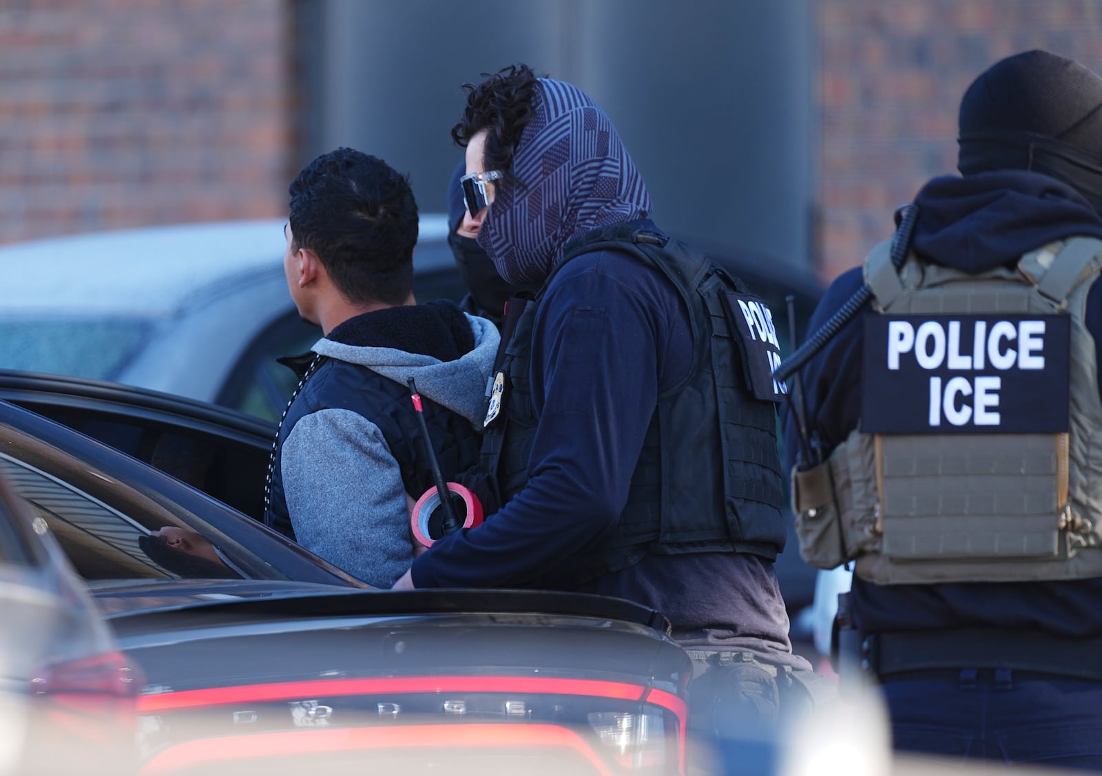 Law officials load a man into a utility vehicle during a raid of an apartmeent complex Wednesday, Feb. 5, 2025, in east Denver. (AP Photo/David Zalubowski)