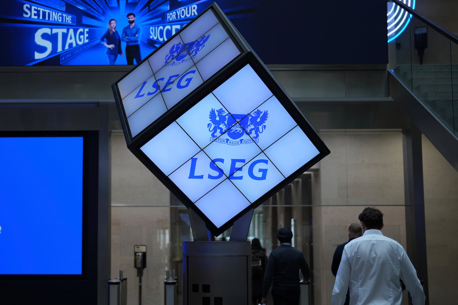 A logo is displayed inside the London Stock Exchange, in the City of London, Monday, March 17, 2025. (AP Photo/Kin Cheung)